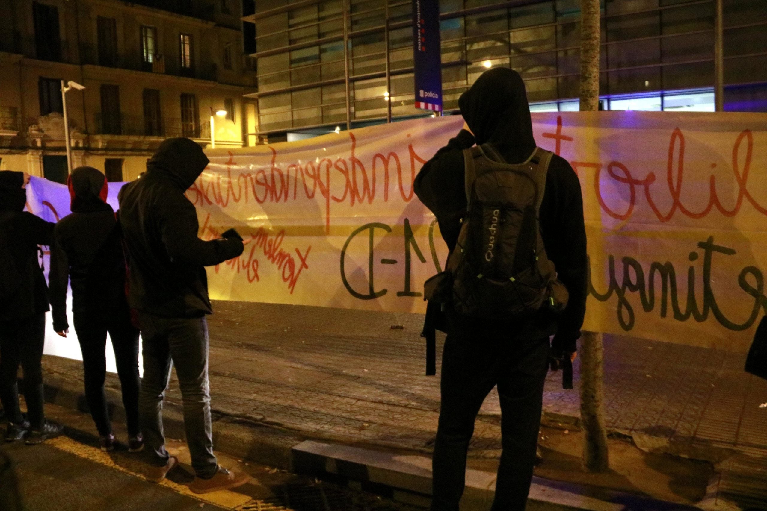 Manifestants subjecten una pancarta davant la comissaria dels Mossos d'Esquadra de Les Corts amb el lema 'llibertat independentistes detingudes 21-D', el 21 de desembre del 2018 / ACN