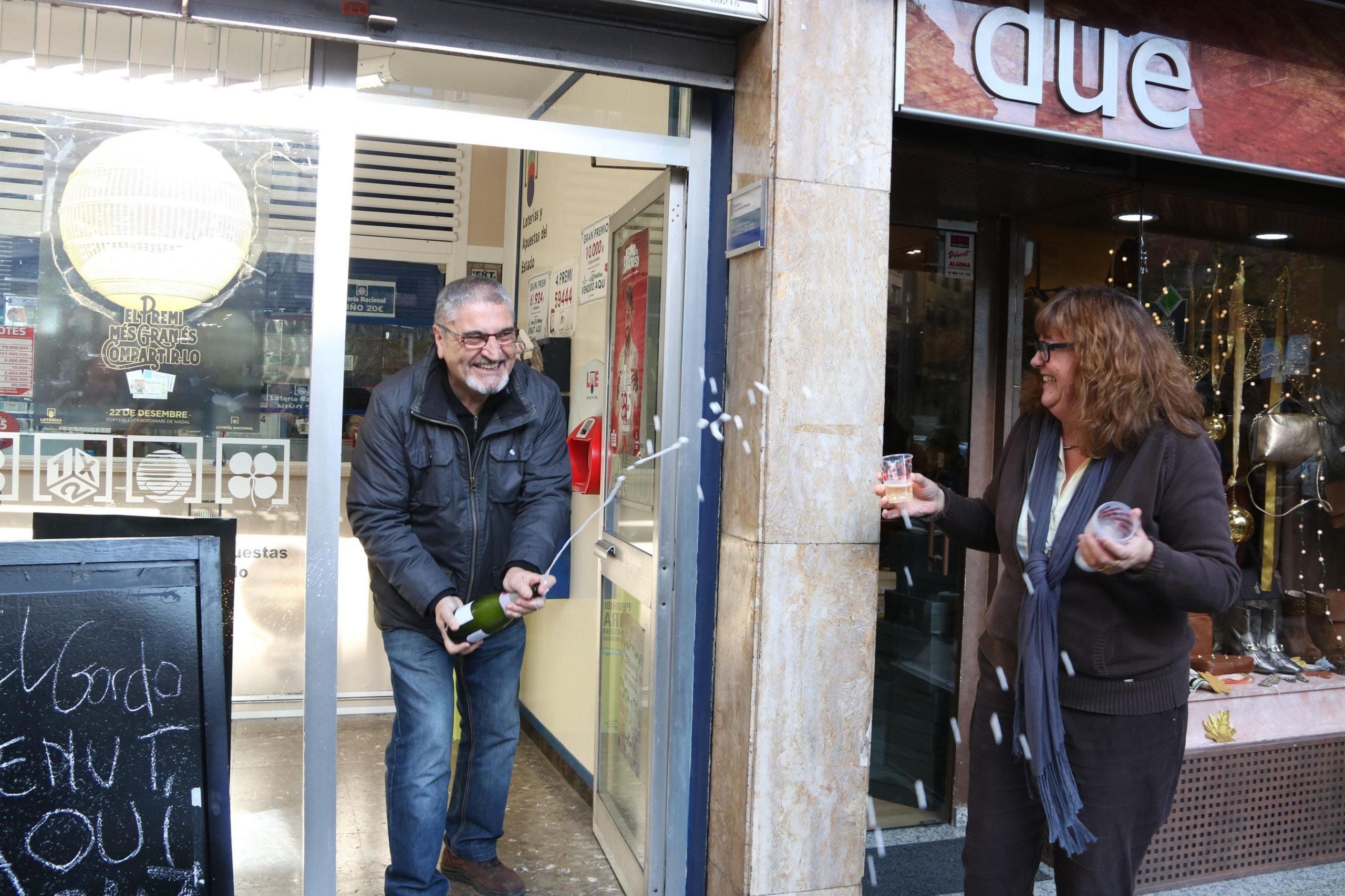 Els propietaris de l'administració del carrer de Sicília 228 de Barcelona destapen una ampolla de cava per celebrar que han venut dècims del primer premi de la loteria de Nadal / ACN