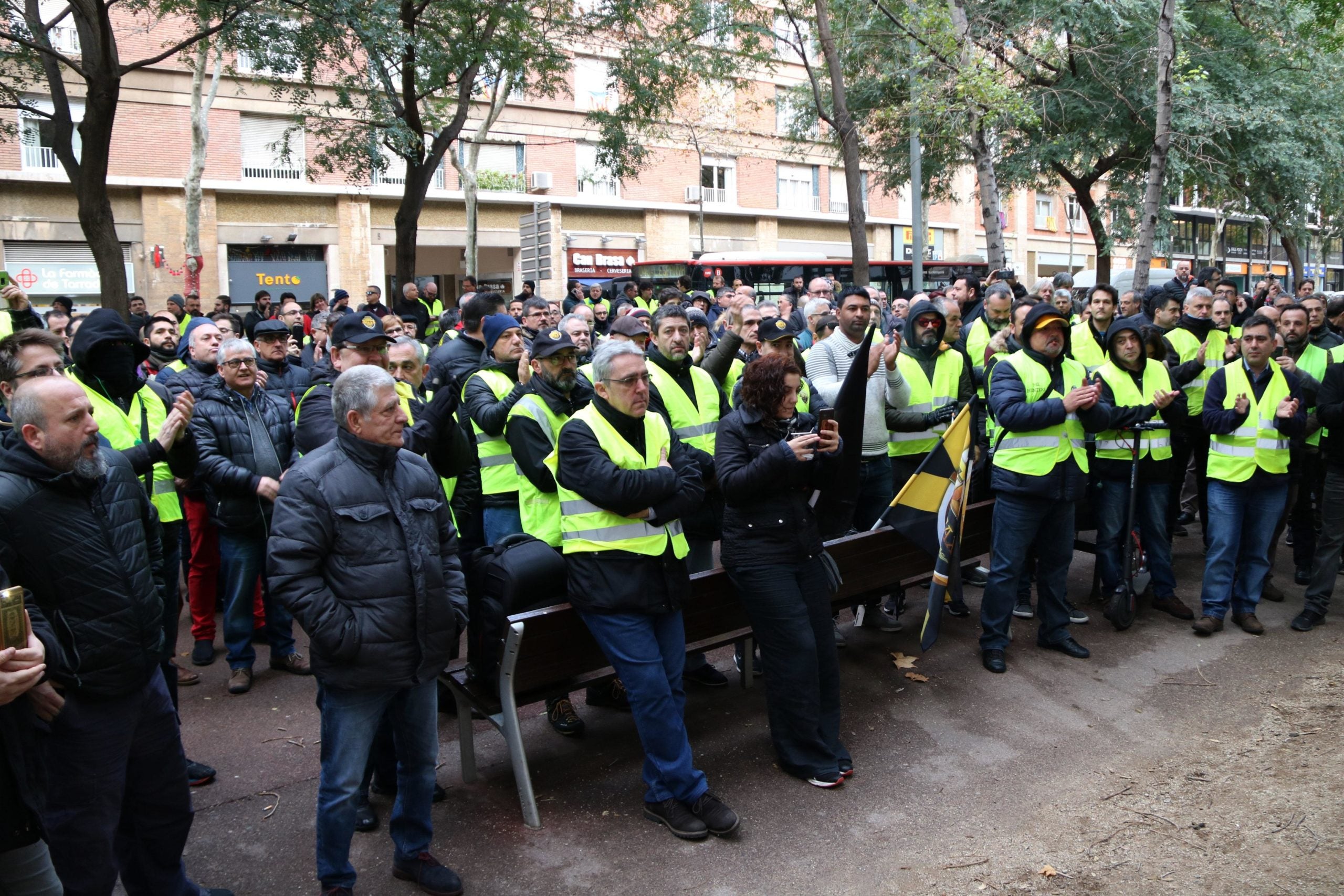 Un grup de taxistes amb armilles grogues davant del departament de Territori que escolten al portaveu d'Élite Taxi, Alberto Álvarez, el 18 de gener de 2019 / ACN