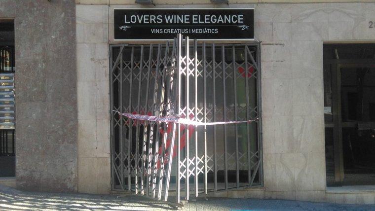 La botiga Lovers Wine Elegance amb les persianes trencades i el precinte dels Mossos / Cedida