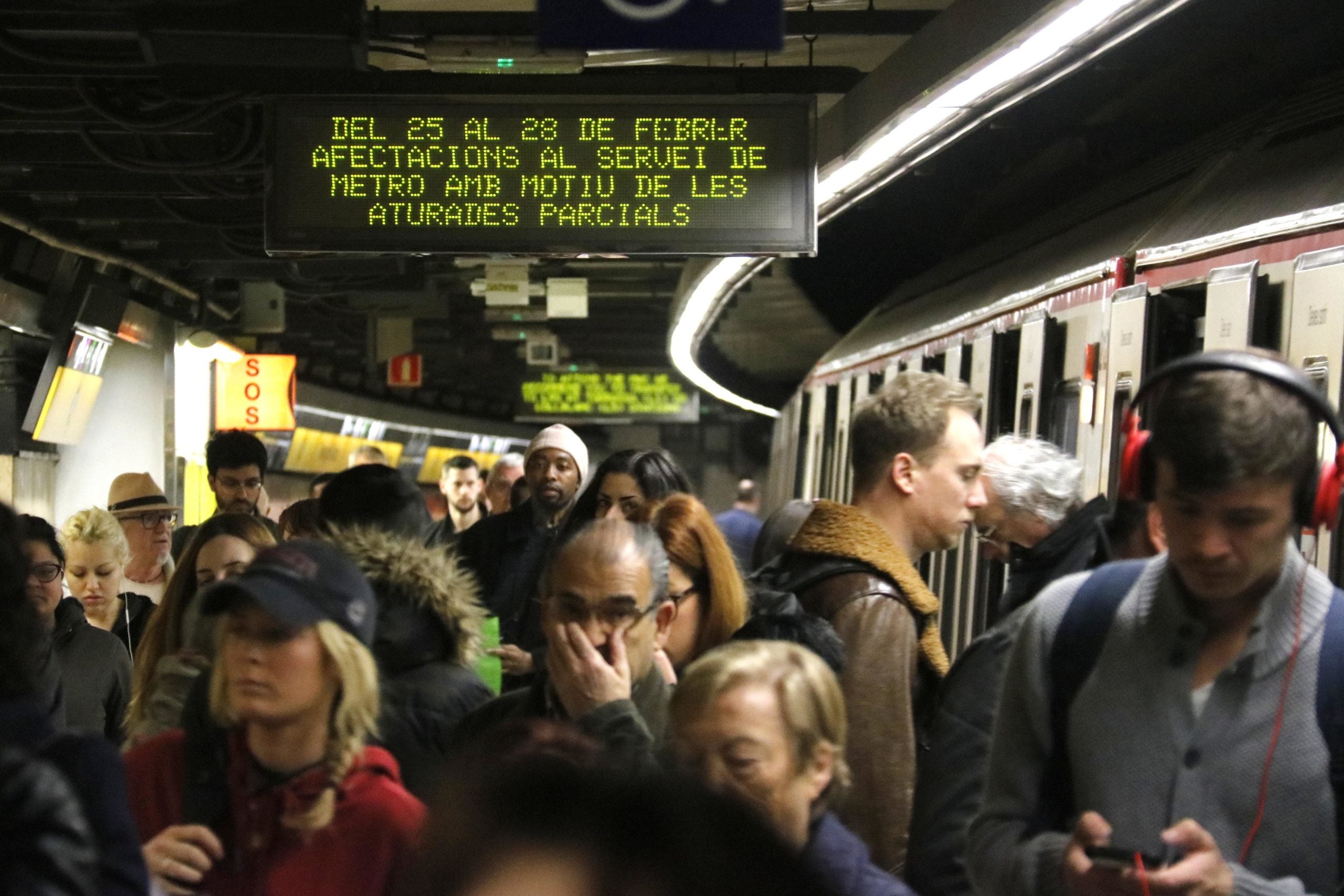 Un cartell anuncia afectacions de la vaga de metro davant l'aglomeració de passatgers, en una imatge d'arxiu / ACN