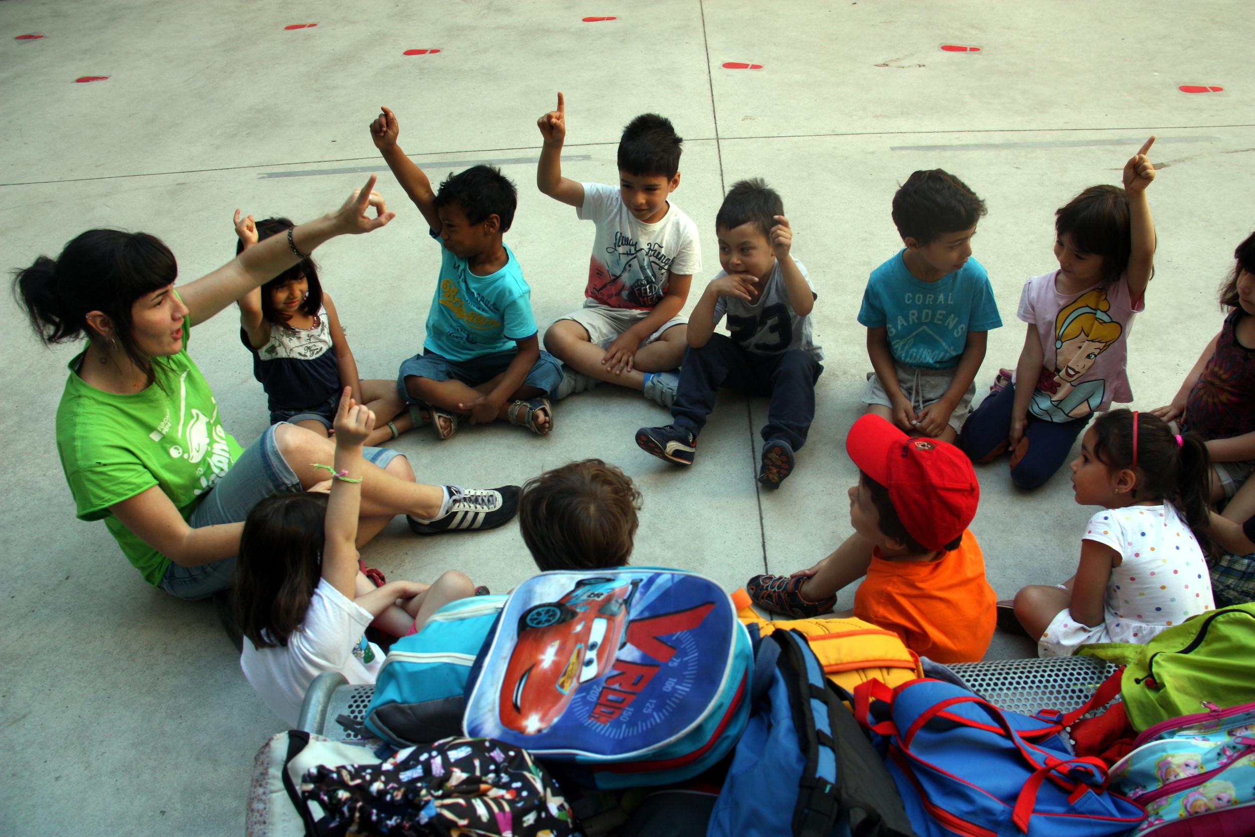 Una monitora amb un grup de menors en una activitat infantil / ACN