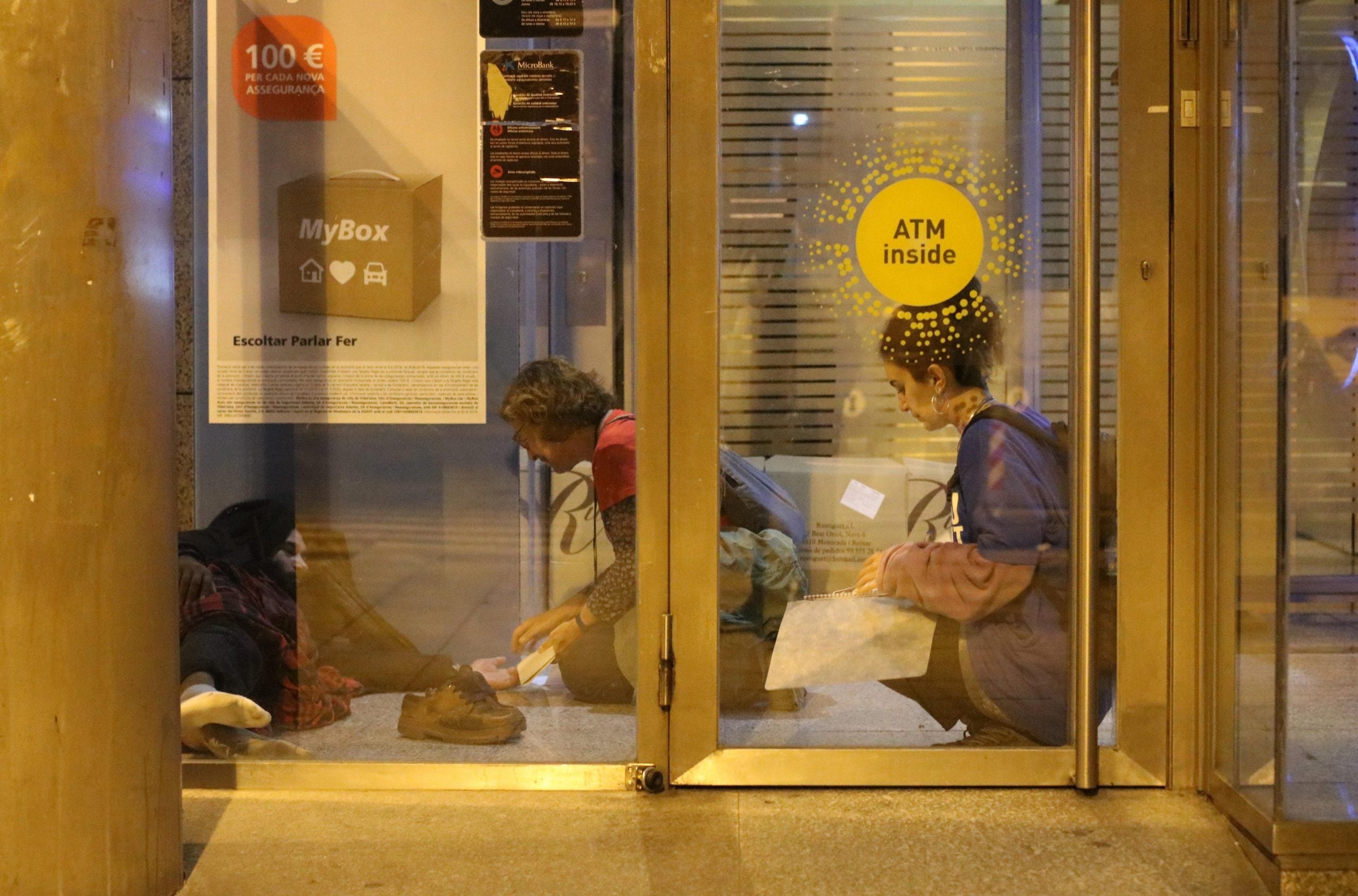 Un voluntari d'Arrels Fundació amb una persona que dorm al carrer | ACN