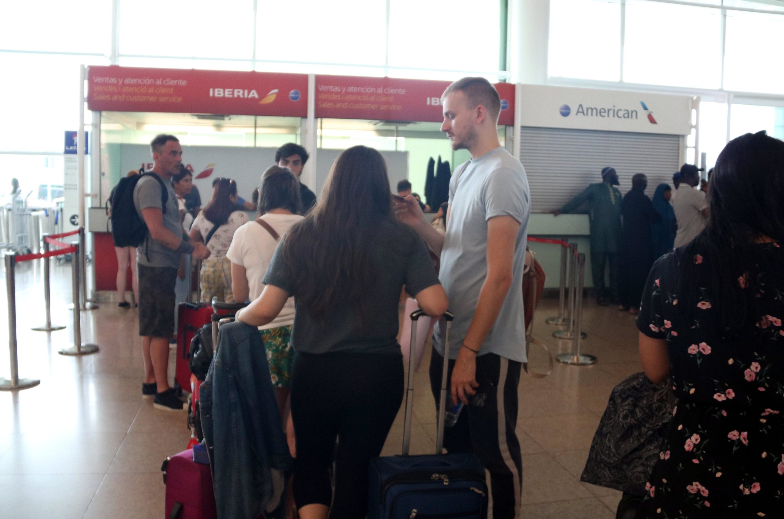 Diversos passatgers davant del taulell de reclamacions d'Ibèria a l'aeroport del Prat, dissabte / ACN