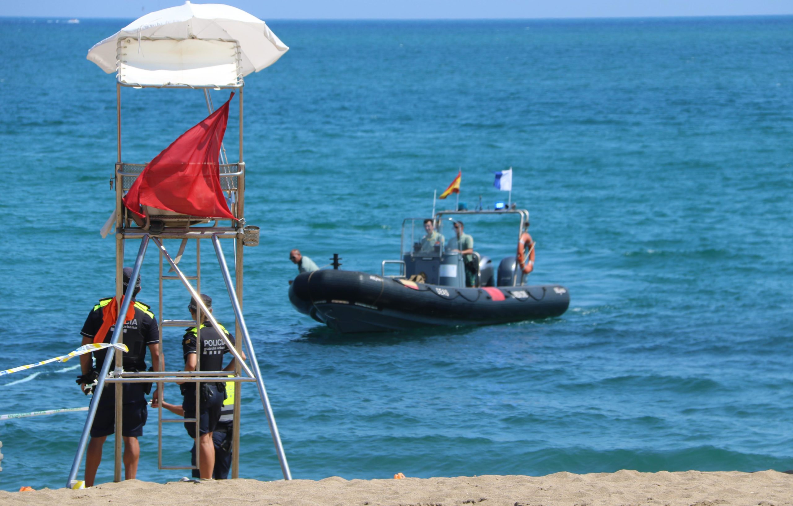 Una embarcació de la Guàrdia Civil a la platja de Sant Sebastià fent tasques al voltant de l'artefacte trobat a l'agost / ACN (Àlex Recolons)