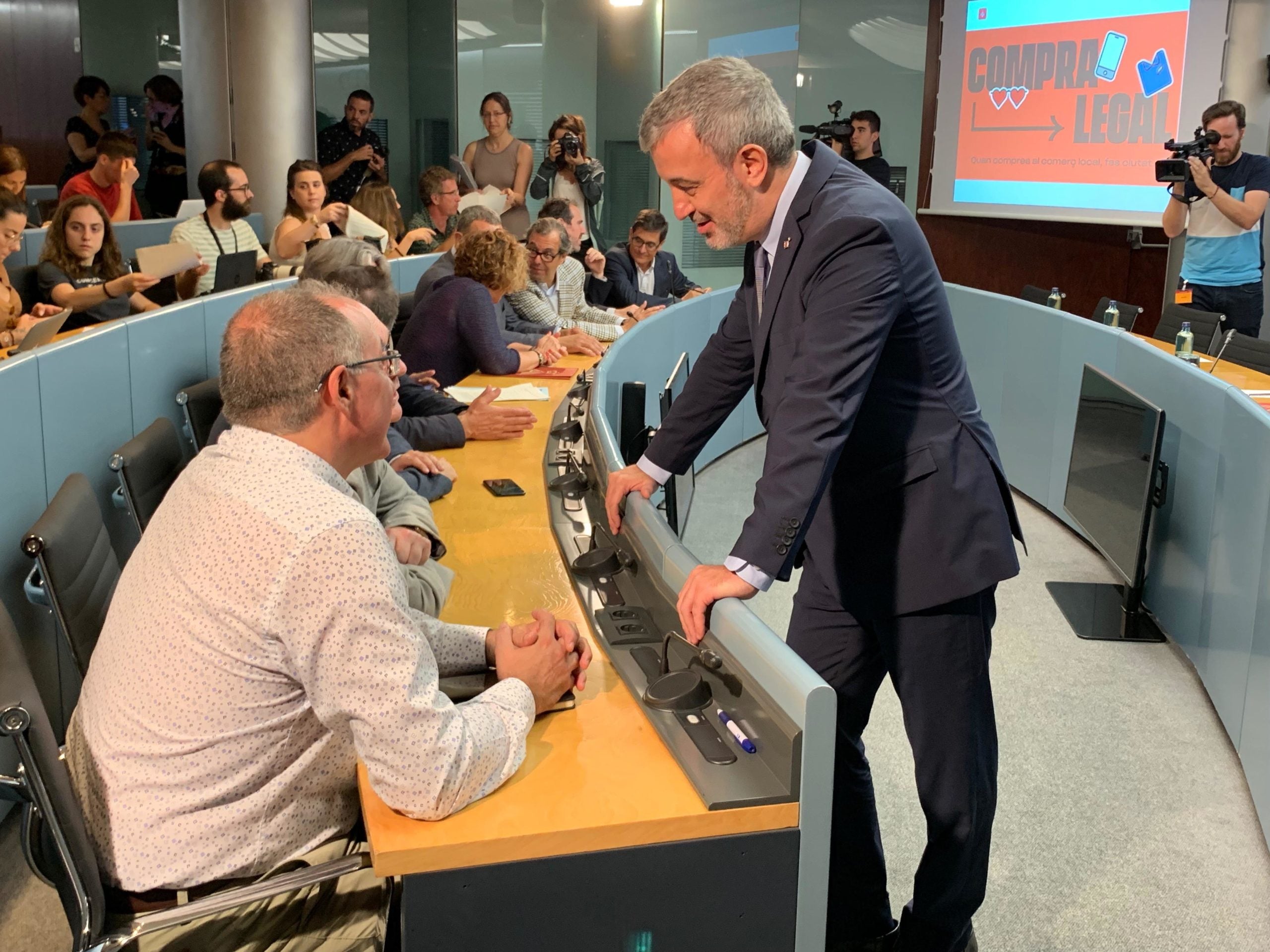 Jaume Collboni, parlant amb representants del comerciants abans de la presentació de la campanya 'Compra legal' / S.B.