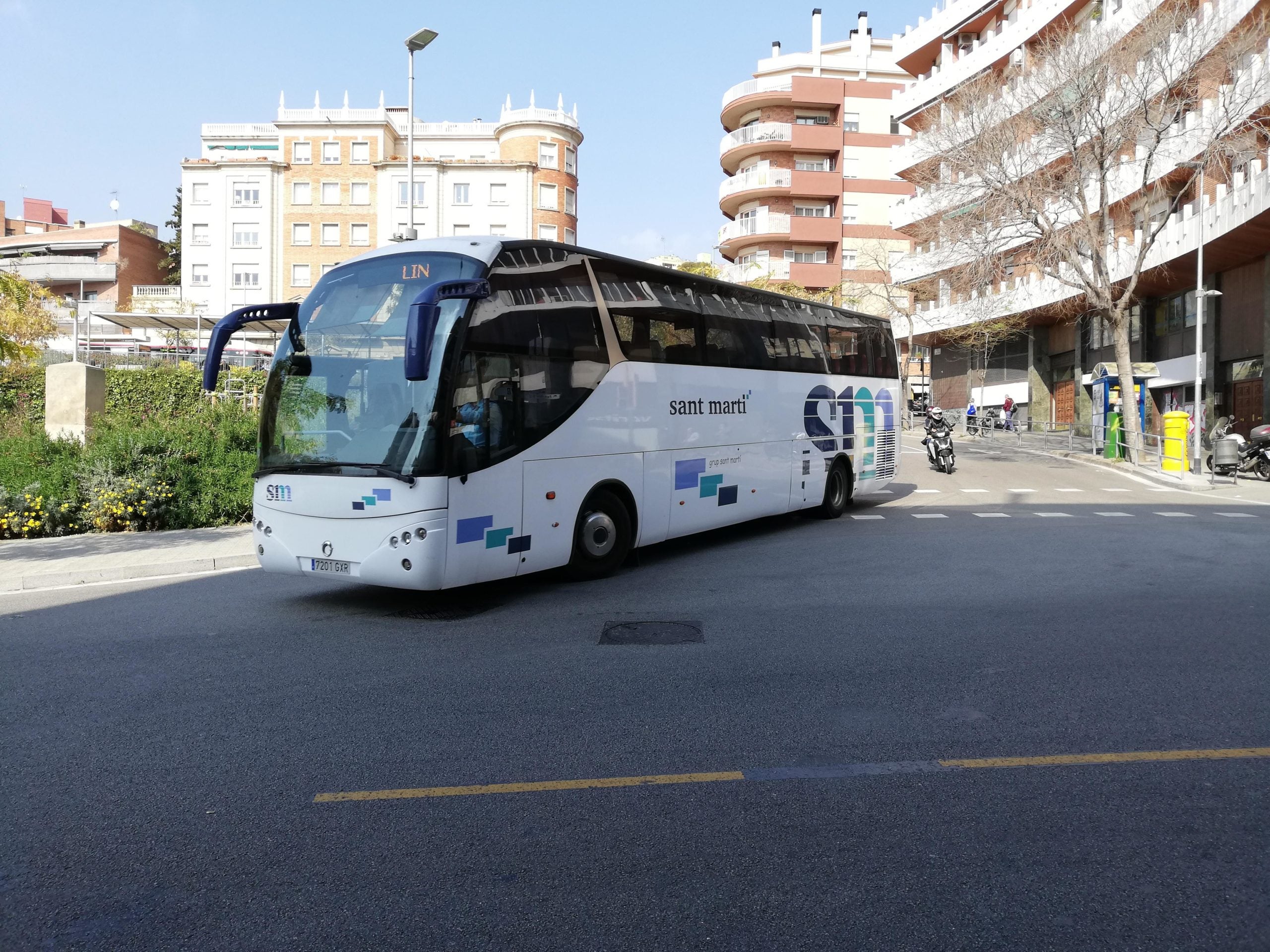Un autocar arriba a la plaça Sanllehy després de deixar un grup de t