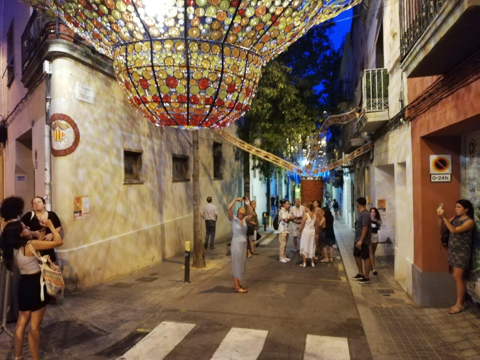Imatge d'arxiu de veïns contemplant i fotografiant el guarnit del carrer Sagunt durant unes altres festes de Sants / Xavi Fernández de Castro