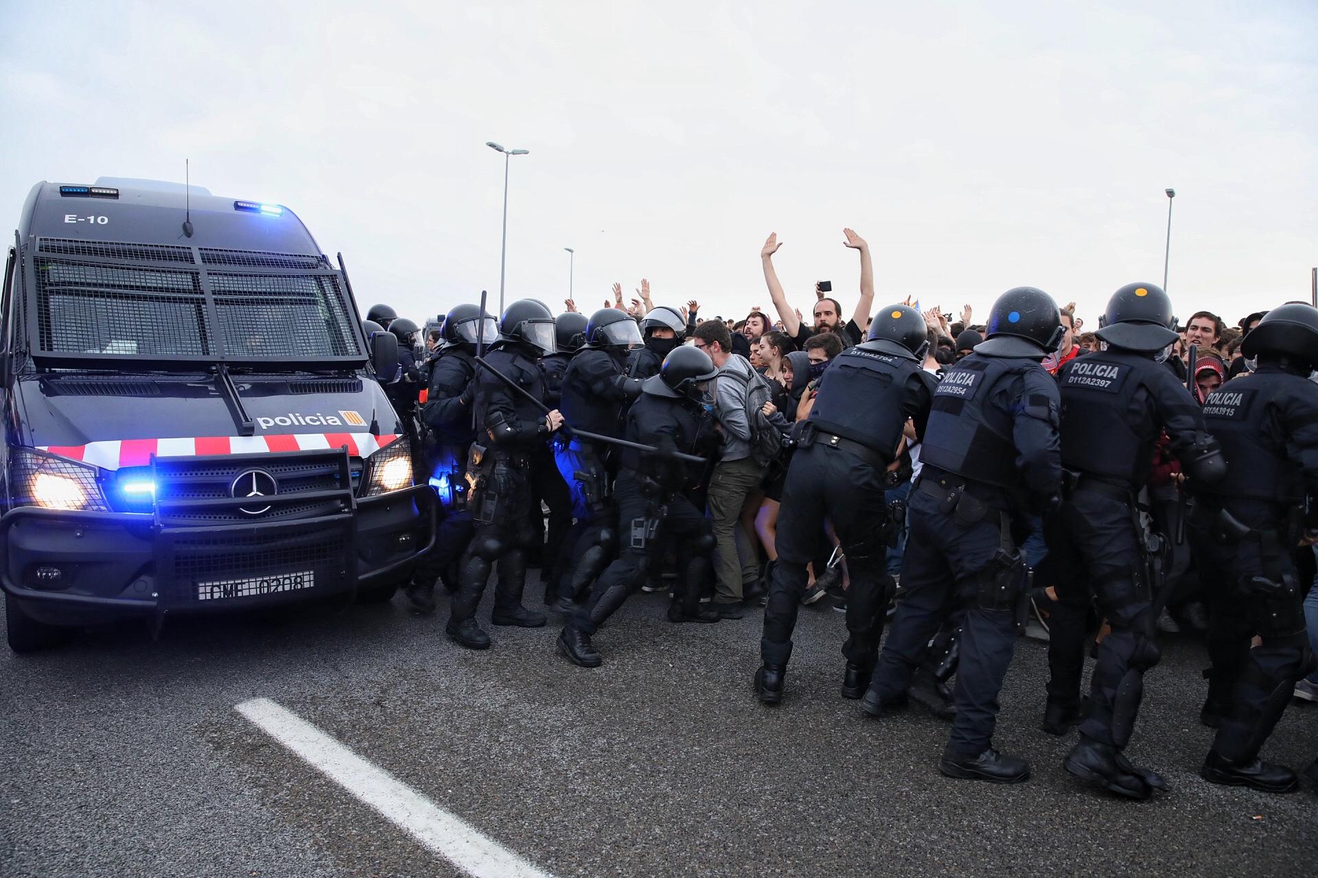 Agents dels antiavalots dels Mossos d'Esquadra empenyent manifestants contra la sentència de l'1-O davant de l'aeroport del Prat / Jordi Play