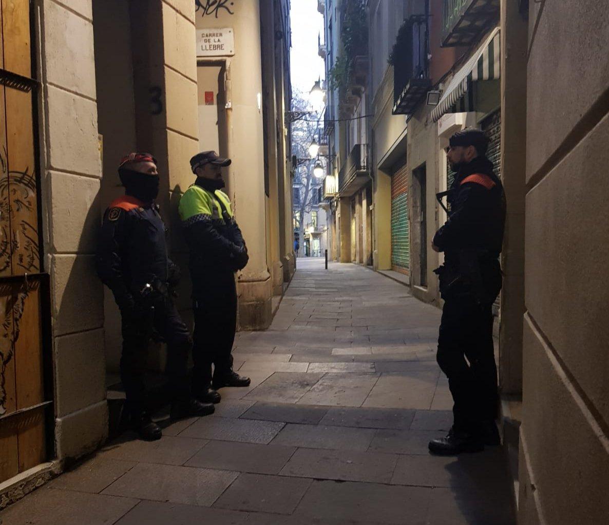 Mossos i agents de la Guàrdia Urbana a la porta d'un narcopís durant una operació conjunta / CME