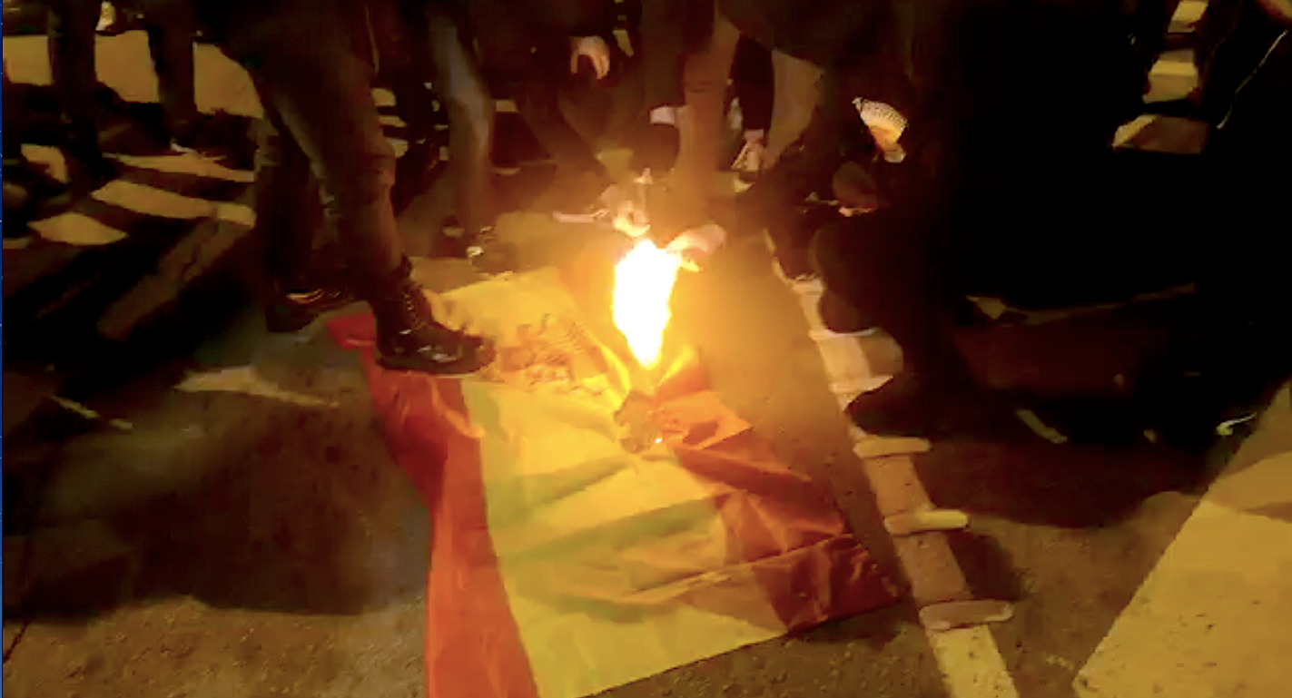 Un moment de la crema de la bandera espanyola al tall de la Meridiana, mentre a una travessia i mitja es manifestaven els ultres contra el tall / D.C.