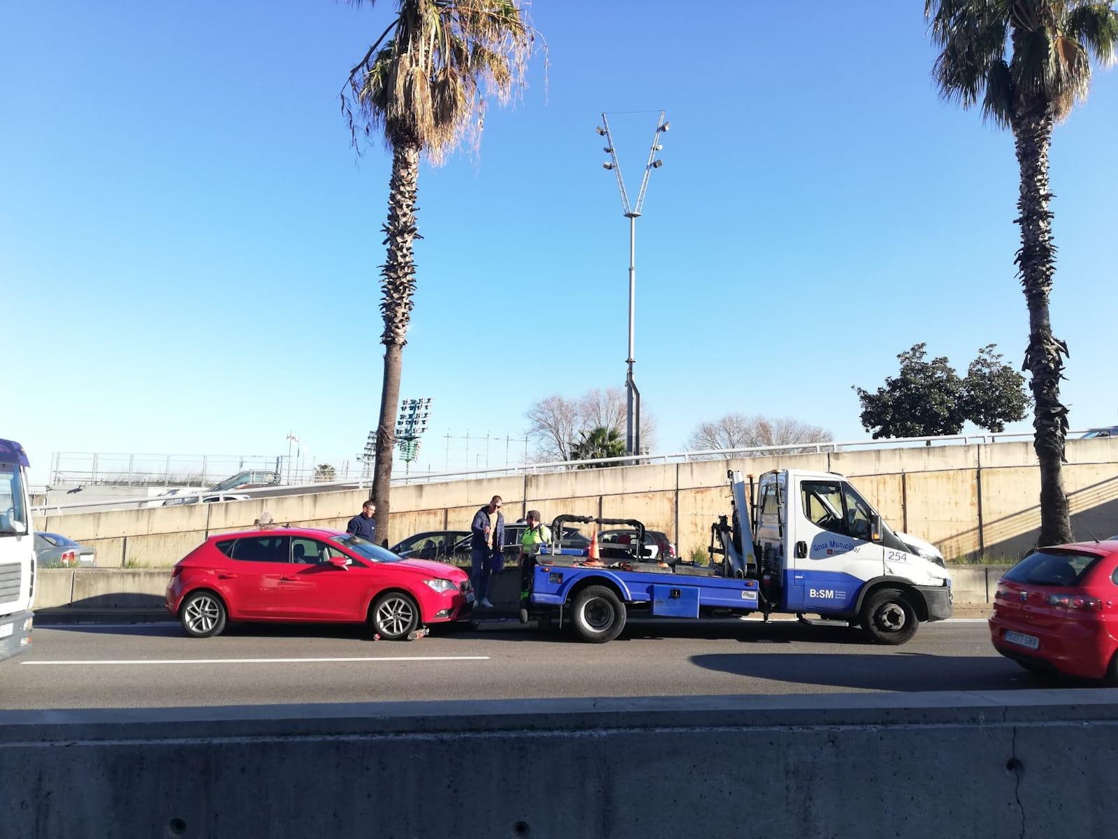 Una grua assisteix a un cotxe accidentat a les Rondes de Barcelona / A