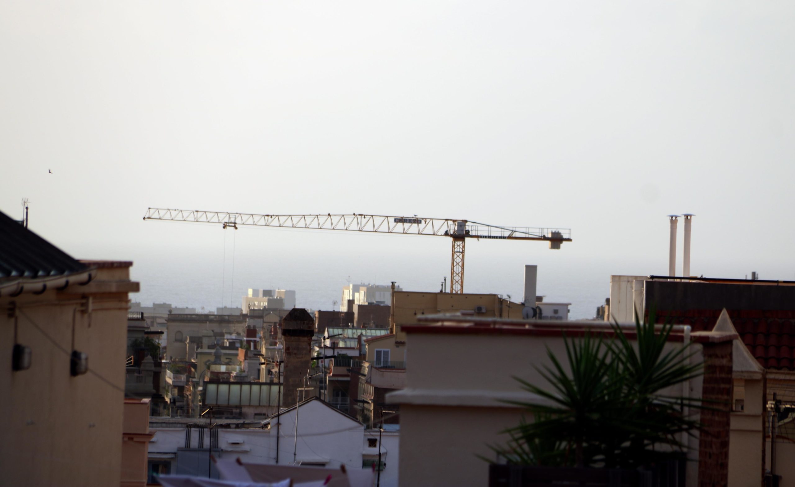 Vista des d'un terrat de Barcelona amb una grua de la construcció treballant a l'Eixample / ACN