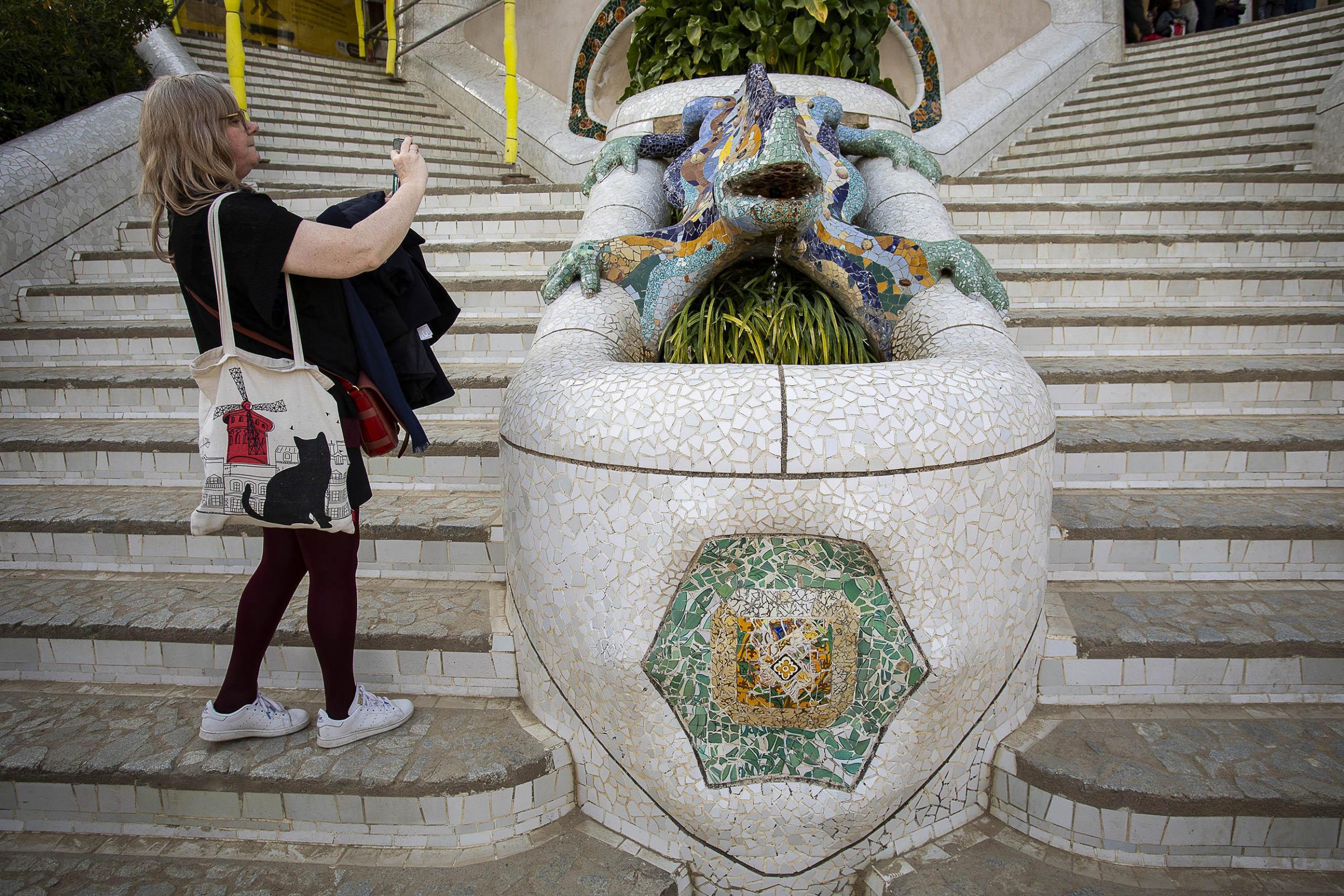 Una turista fotografia a soles el drac del Park Güell, quasi buit per la por al coronavirus / Jordi Play