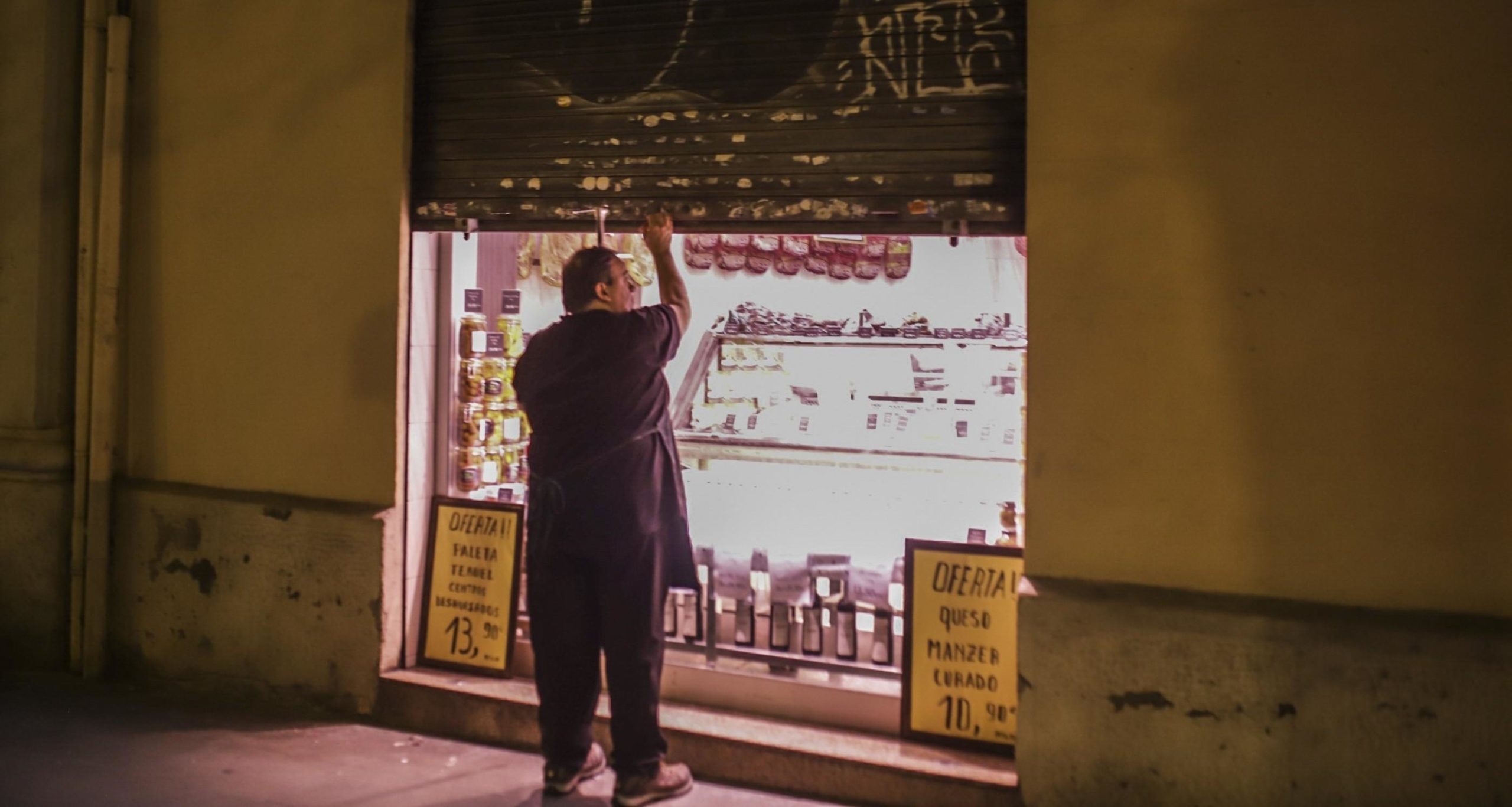 Un comerciant amb la persiana a mig baixar, a Barcelona / Europa Press