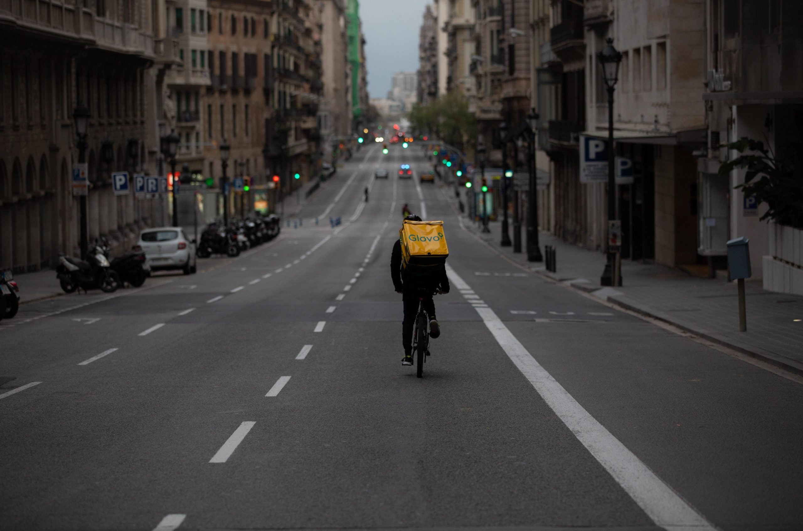 Un repartidor de Glovo en bicicleta baixa sol per la Via Laietana durant l'estat d'alarma / Europa Press