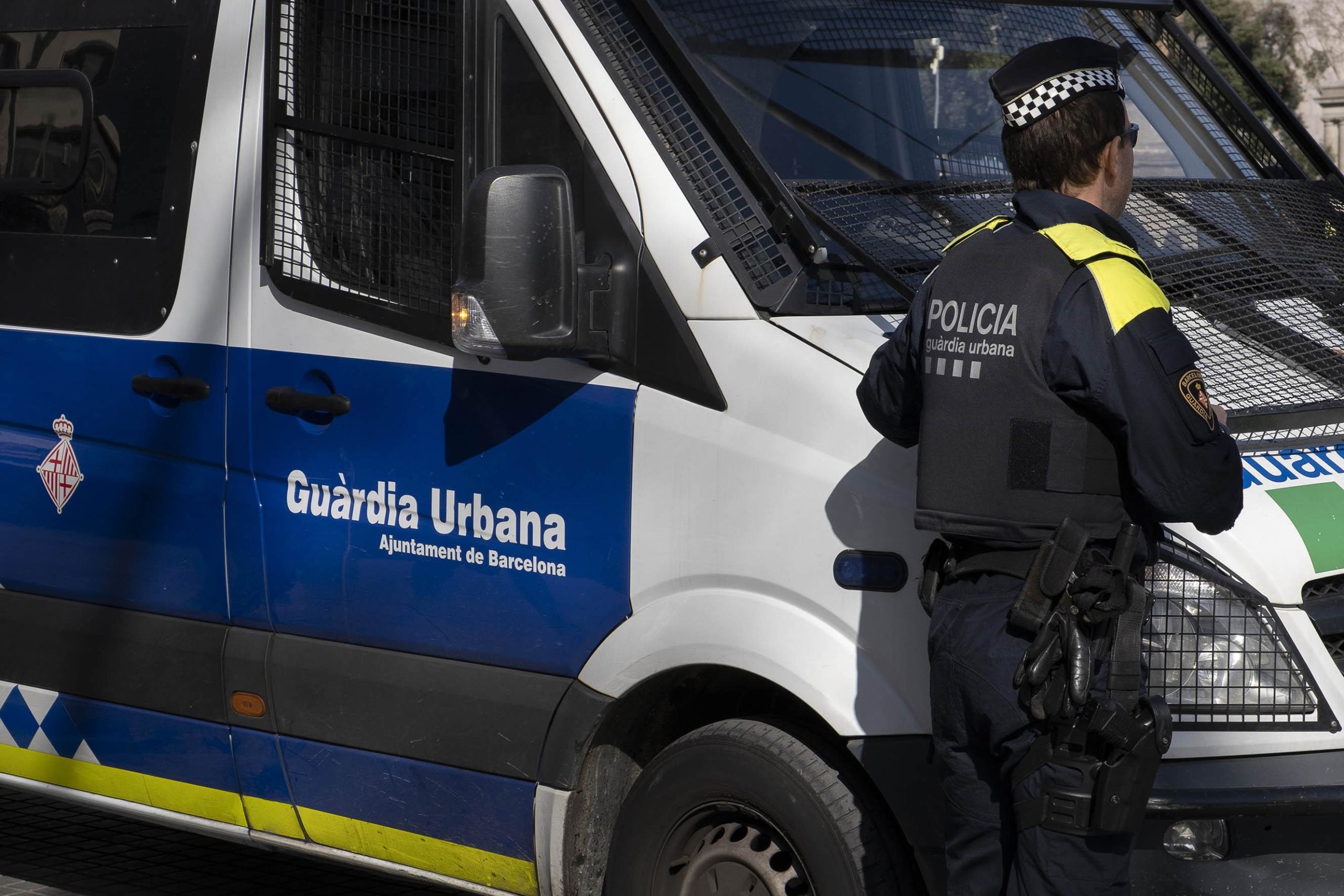 Un agent de la Guàrdia Urbana, al costat d'un furgó del cos, al centre de Barcelona / Jordi Play