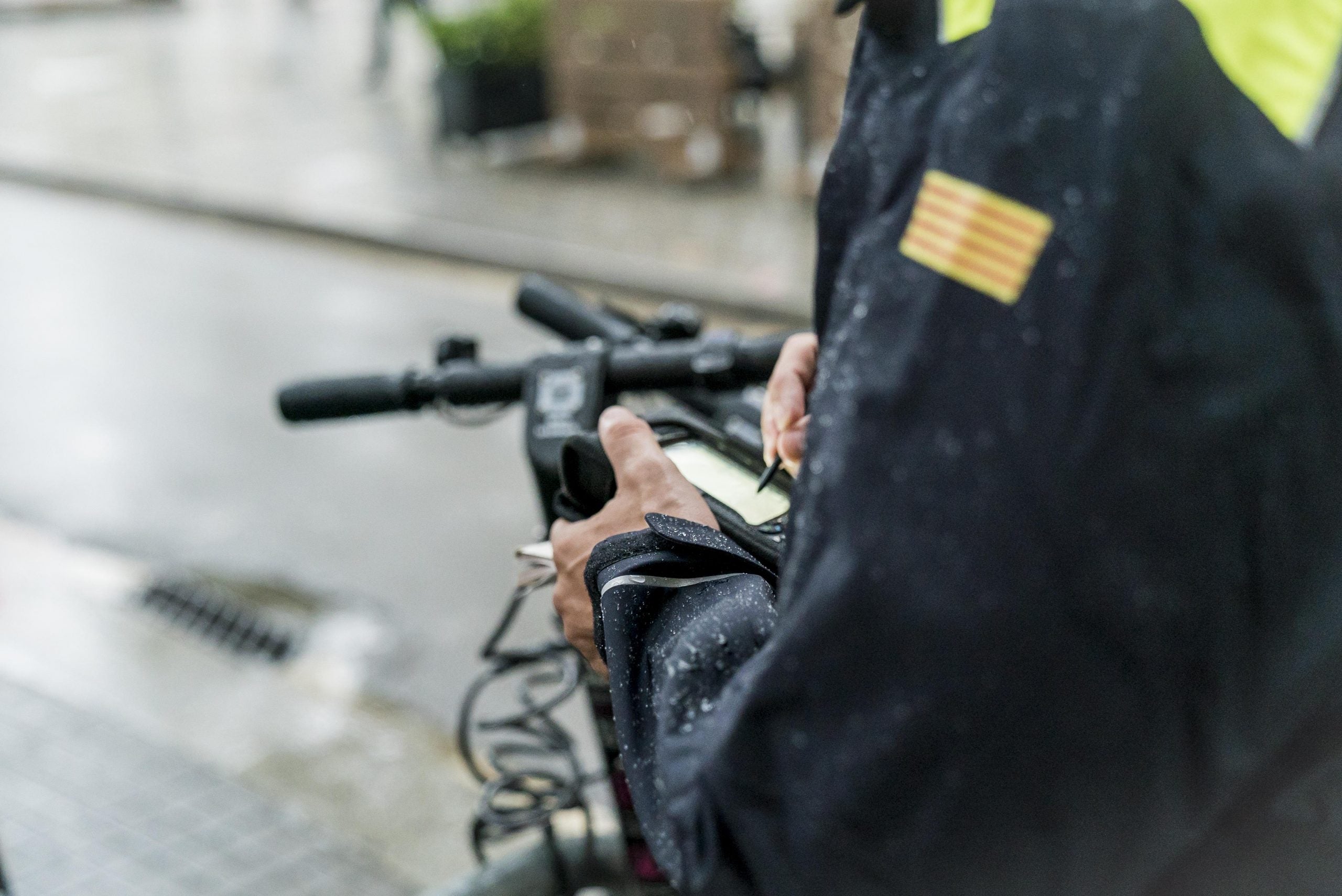 Un agent de la Guàrdia Urbana al costat d'un patinet, en imatge d'arxiu | Ajuntament de Barcelona