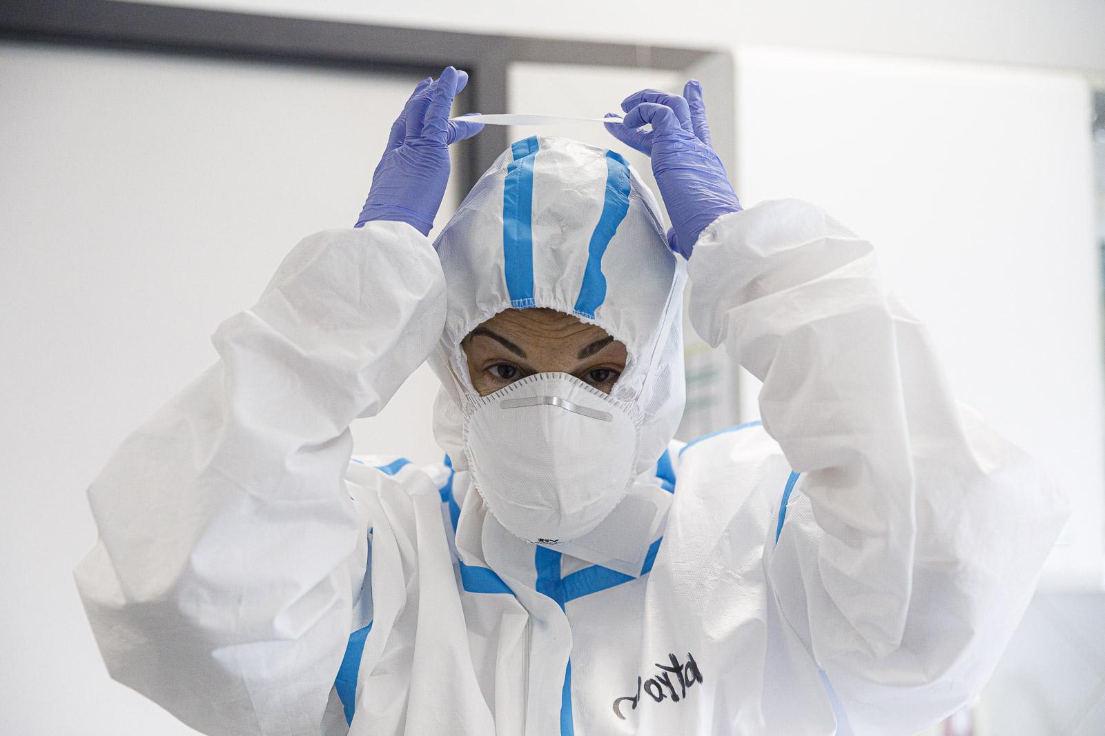 Una infermera del CAP Sant Andreu equipada amb la granota per treballar en zona de pandèmia de covid-19 causada pel coronavirus, posant-se la mascareta / Jordi Borràs Una infermera del CAP Sant Andreu equipada amb la granota per treballar en zona de pandèmia de covid-19 causada pel coronavirus, posant-se la mascareta / Jordi Borràs