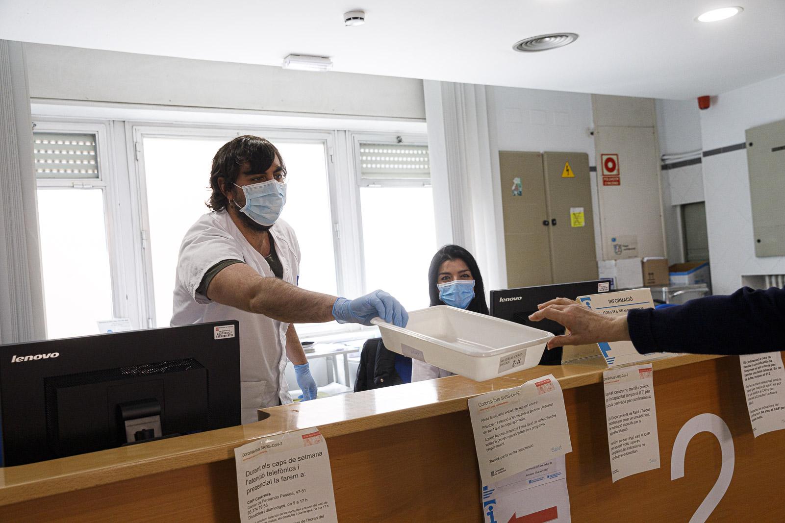 Una pacient diposita la targeta sanitària en una safata mantenint la distància de seguretat amb els administratius del mostrador al CAP Sant Andreu, durant la pandèmia de covid-19 causada pel coronavirus / Jordi Borràs Una pacient diposita la targeta sanitària en una safata mantenint la distància de seguretat amb els administratius del mostrador al CAP Sant Andreu, durant la pandèmia de covid-19 causada pel coronavirus / Jordi Borràs