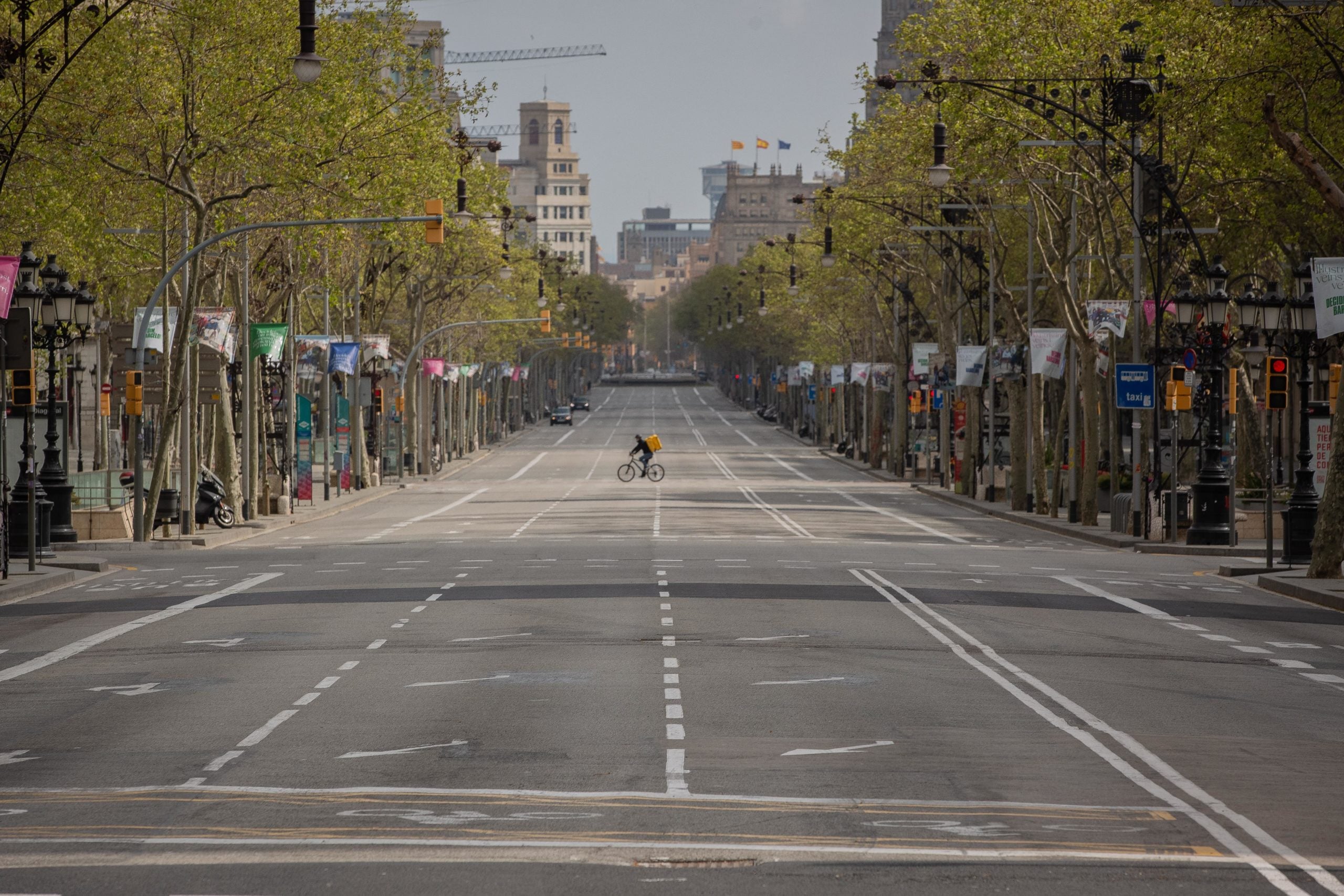 Un repartidor de Glovo en bicicleta, rei del passeig de Gràcia buit, durant l'estat d'alarma a Barcelona pel coronavirus / David Zorrakino - Europa Press