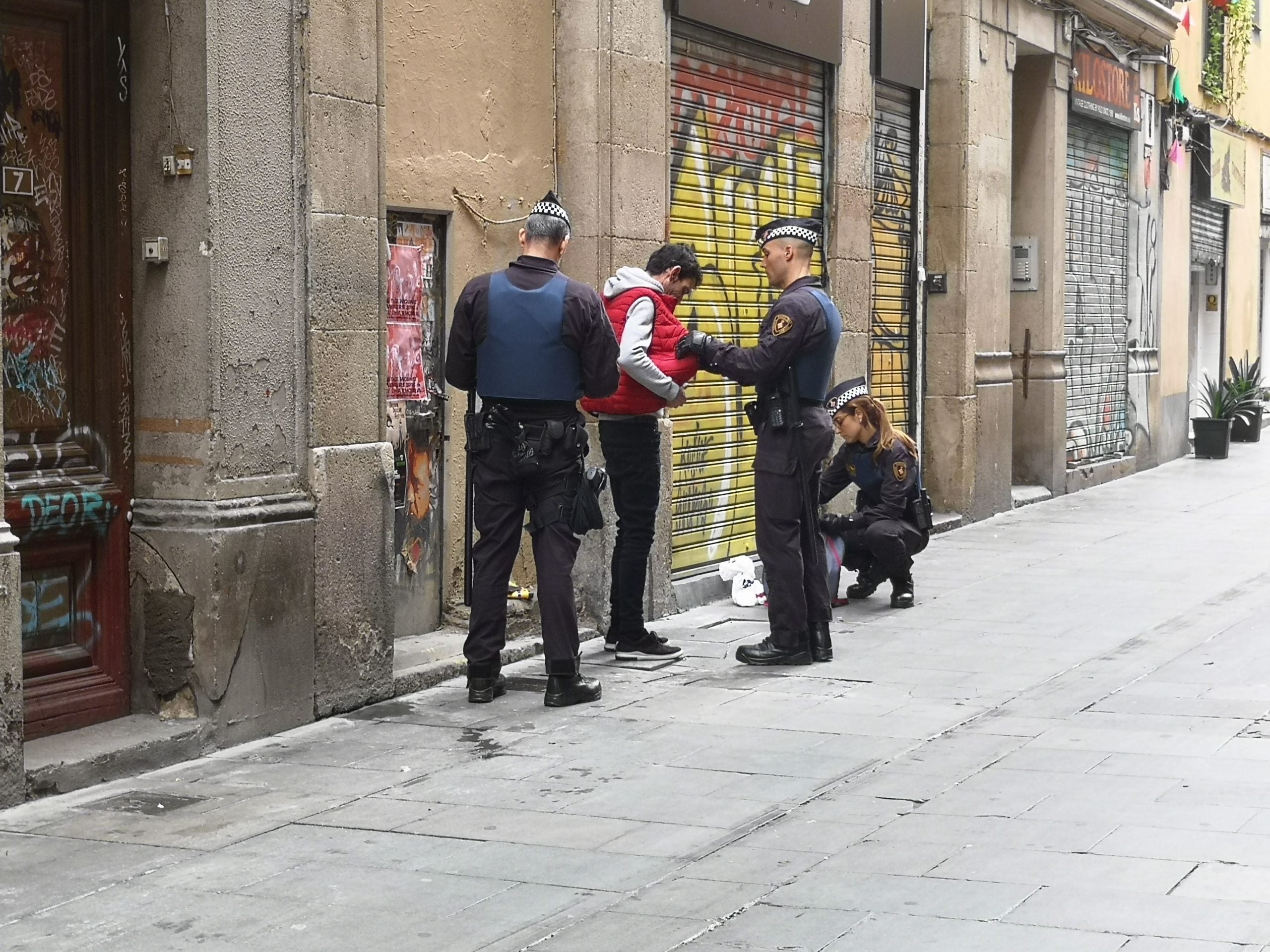 La Unitat de Policia Administrativa i de Seguretat (UPAS) de la Guàrdia Urbana registrant un home al carrer Riera Baixa / D.C.