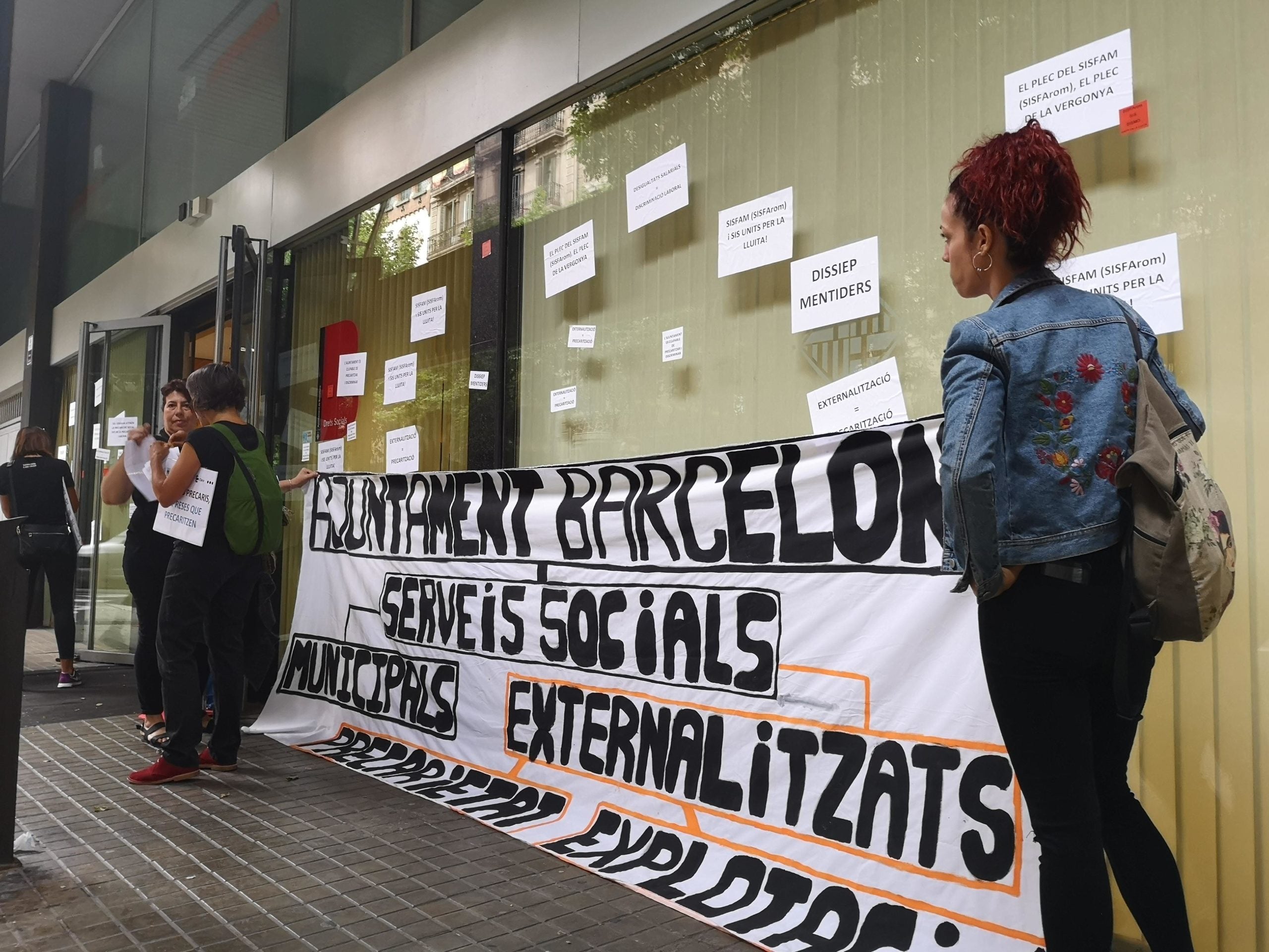 La pancarta desplegada per treballadores al davant del departament municipal de Drets Socials. / D.C. La pancarta desplegada per treballadores al davant del departament municipal de Drets Socials. / D.C.