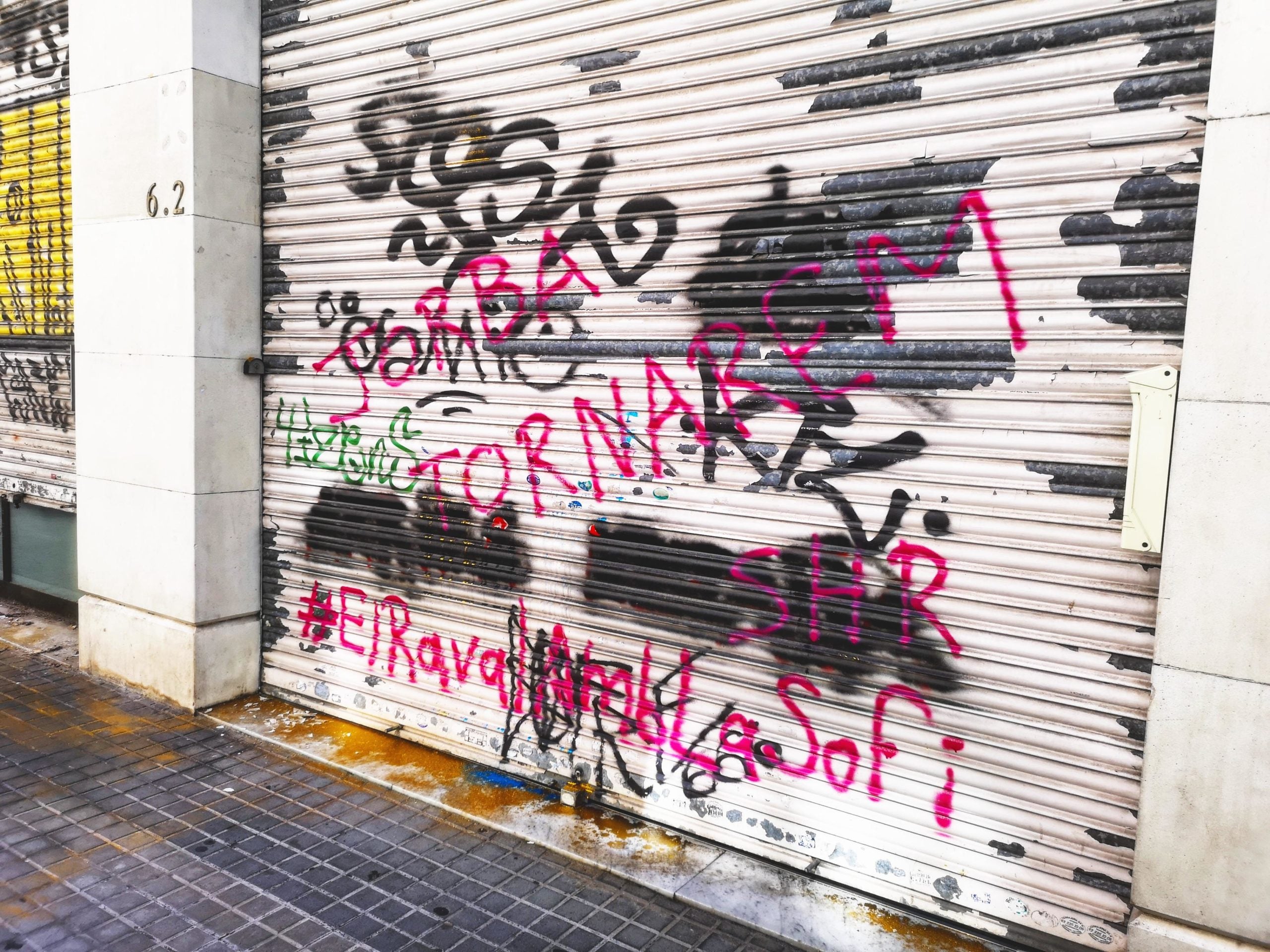 La persiana del negoci Landia Bcn pintada amb l'avís 