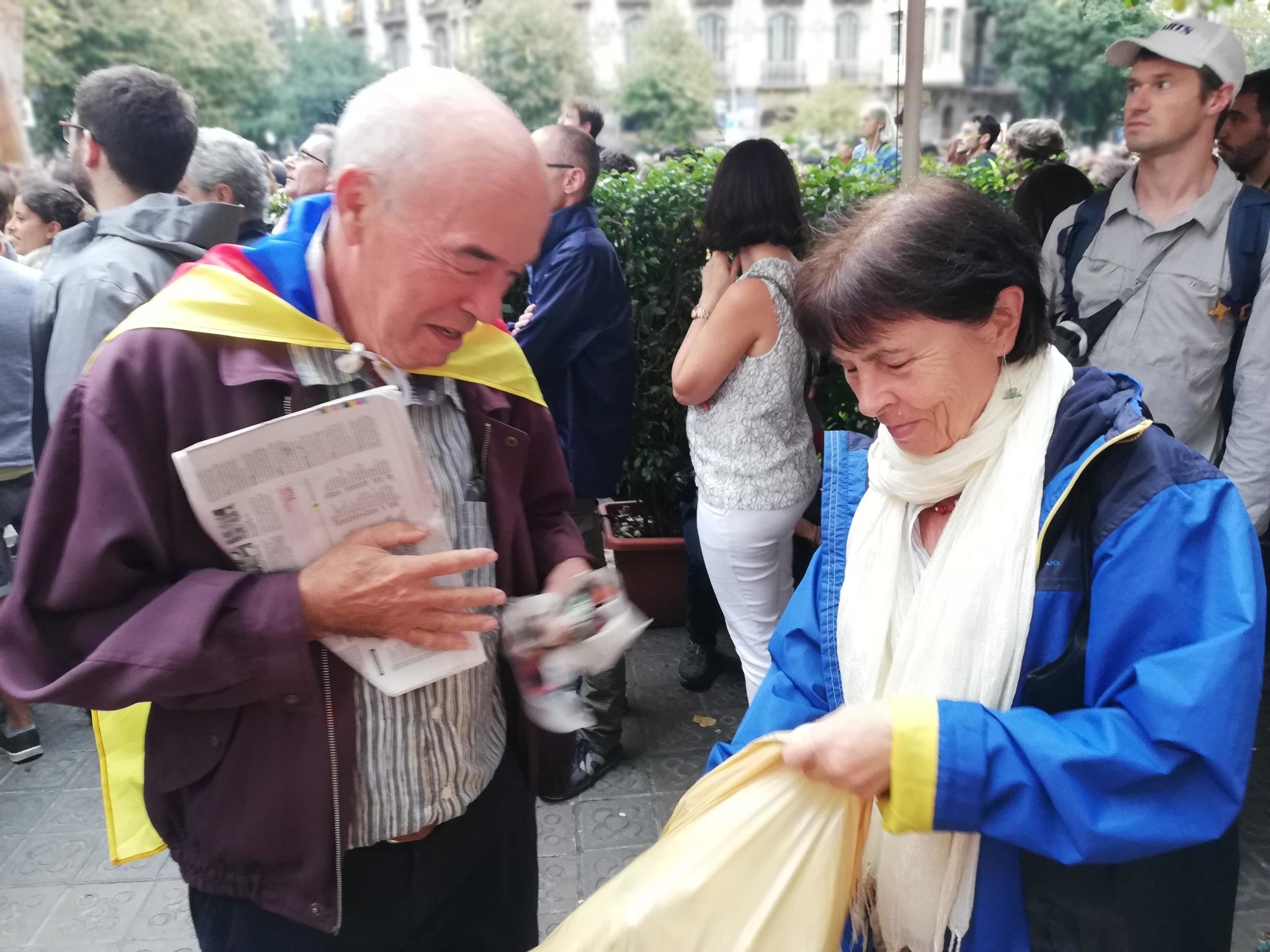 Dos manifestants omplen una bossa de brossa per llançar-la a la Delegació del govern espanyol / Adrià Lizand