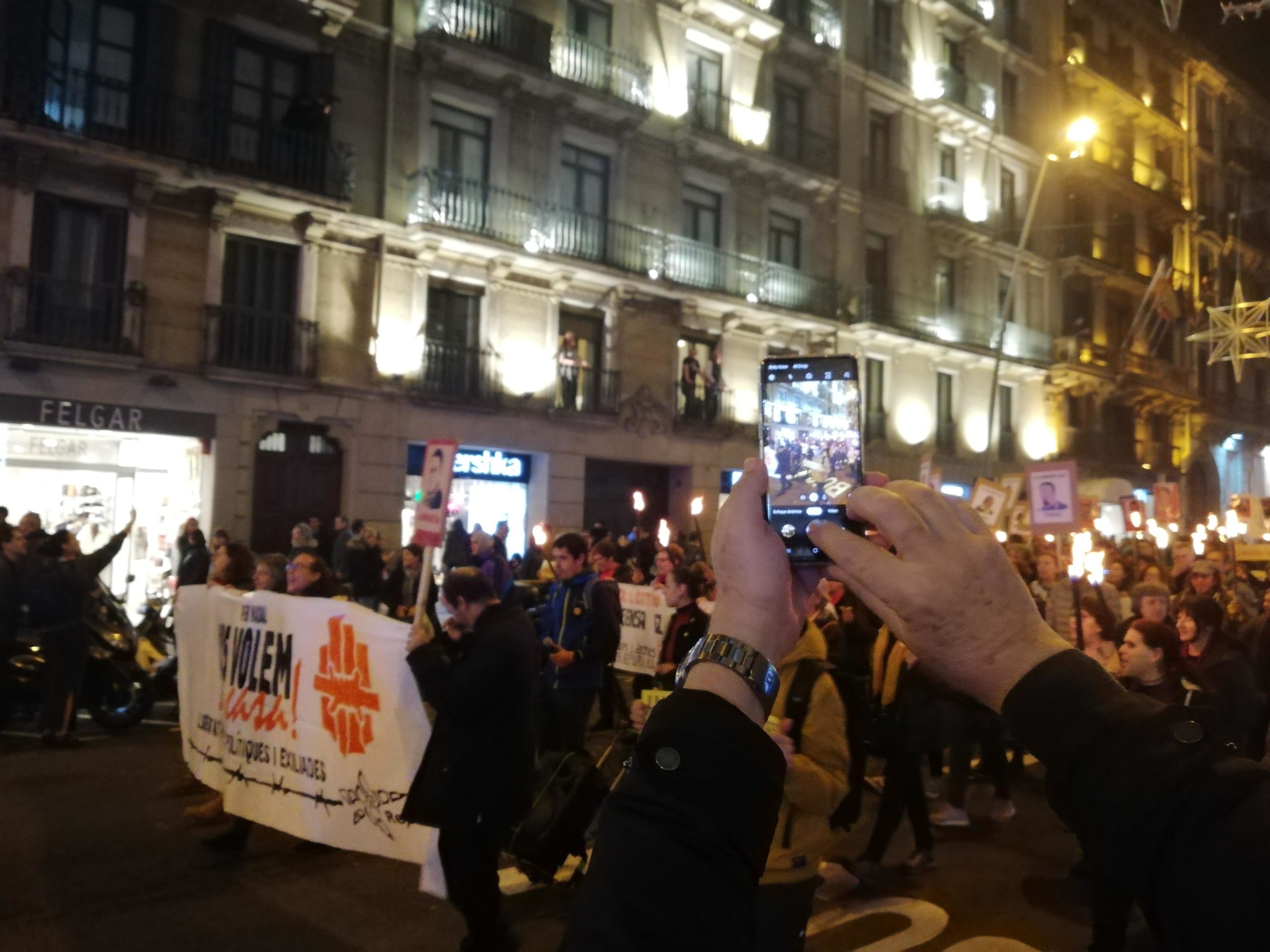 Un turista fotografia la marxa al seu pas per carrer Pelai | Adrià Lizanda