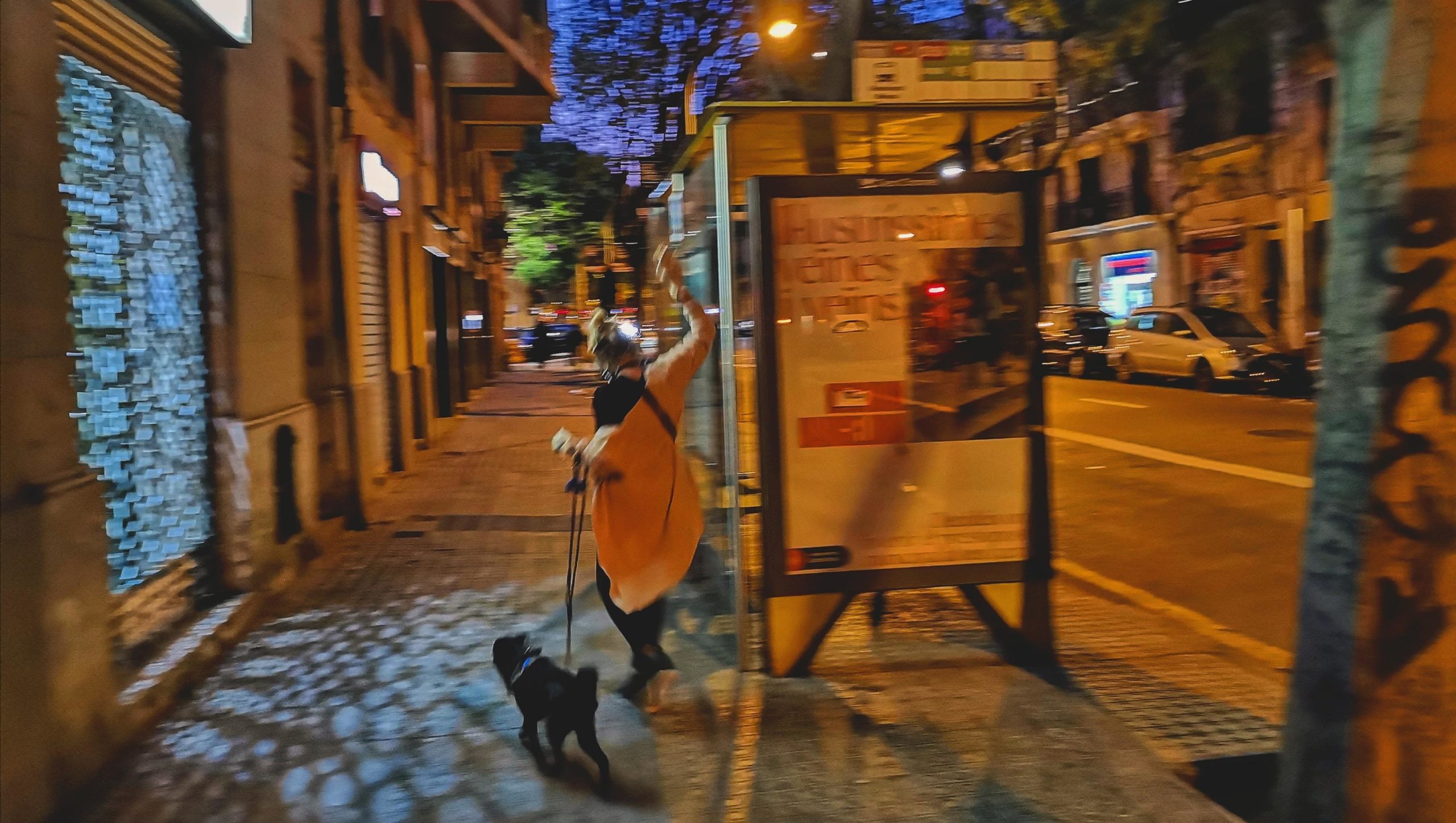 Una veïna passeja el gos i alça del braç, ballant la música dels balcons de Viladomat / D.C. Una veïna passeja el gos i alça del braç, ballant la música dels balcons de Viladomat / D.C.