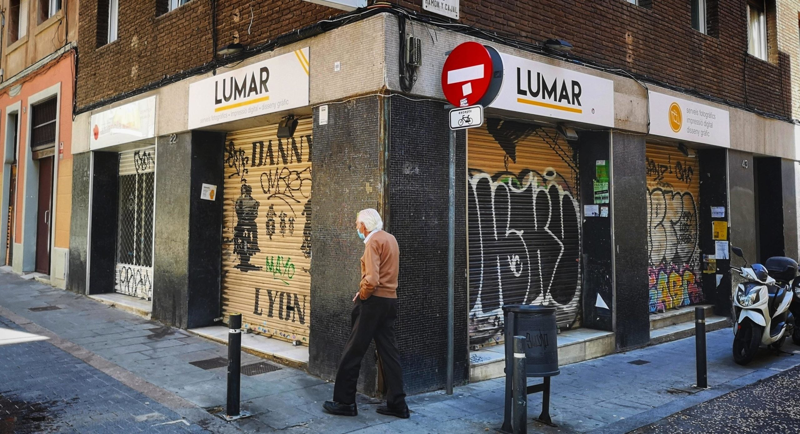 Un home passeja a Gràcia davant del local de Fotografia Lumar, un dels locals que quedaran tancats / D.C.