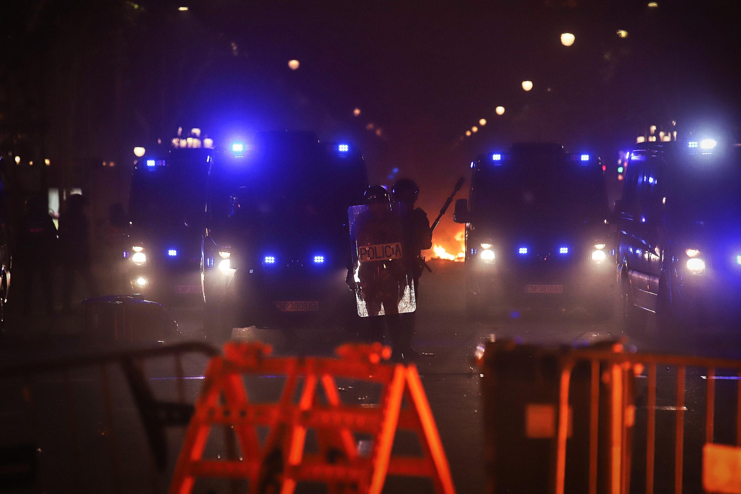 Dos antiavalots amb una foguera al fons, en la segona nit de protesta a Barcelona contra la sentència de l'1-O / Jordi Borràs