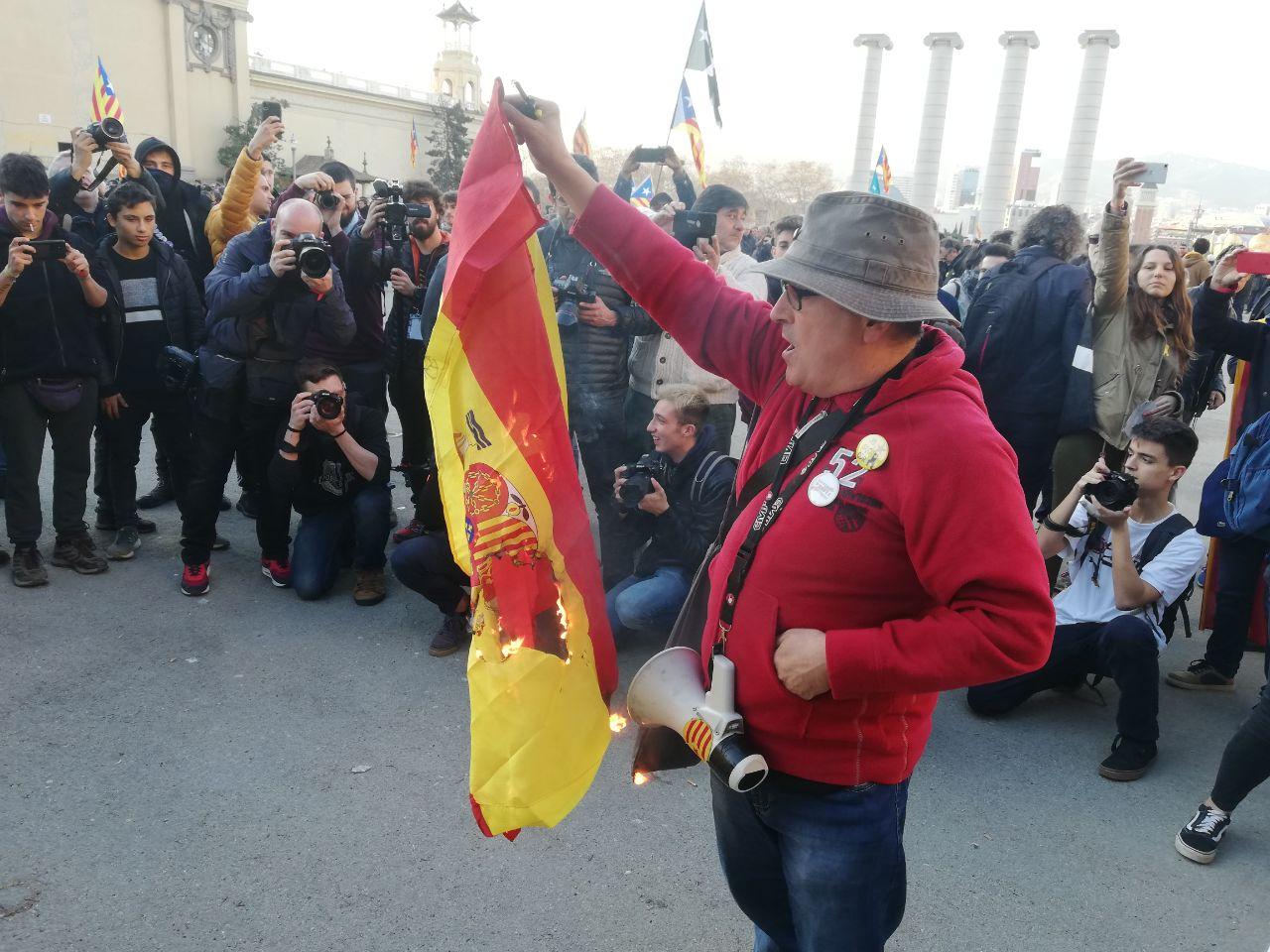 Un manifestant crema una bandera espanyola en la protesta contra Felip VI en la inauguració del MWC 2019 / A.L.