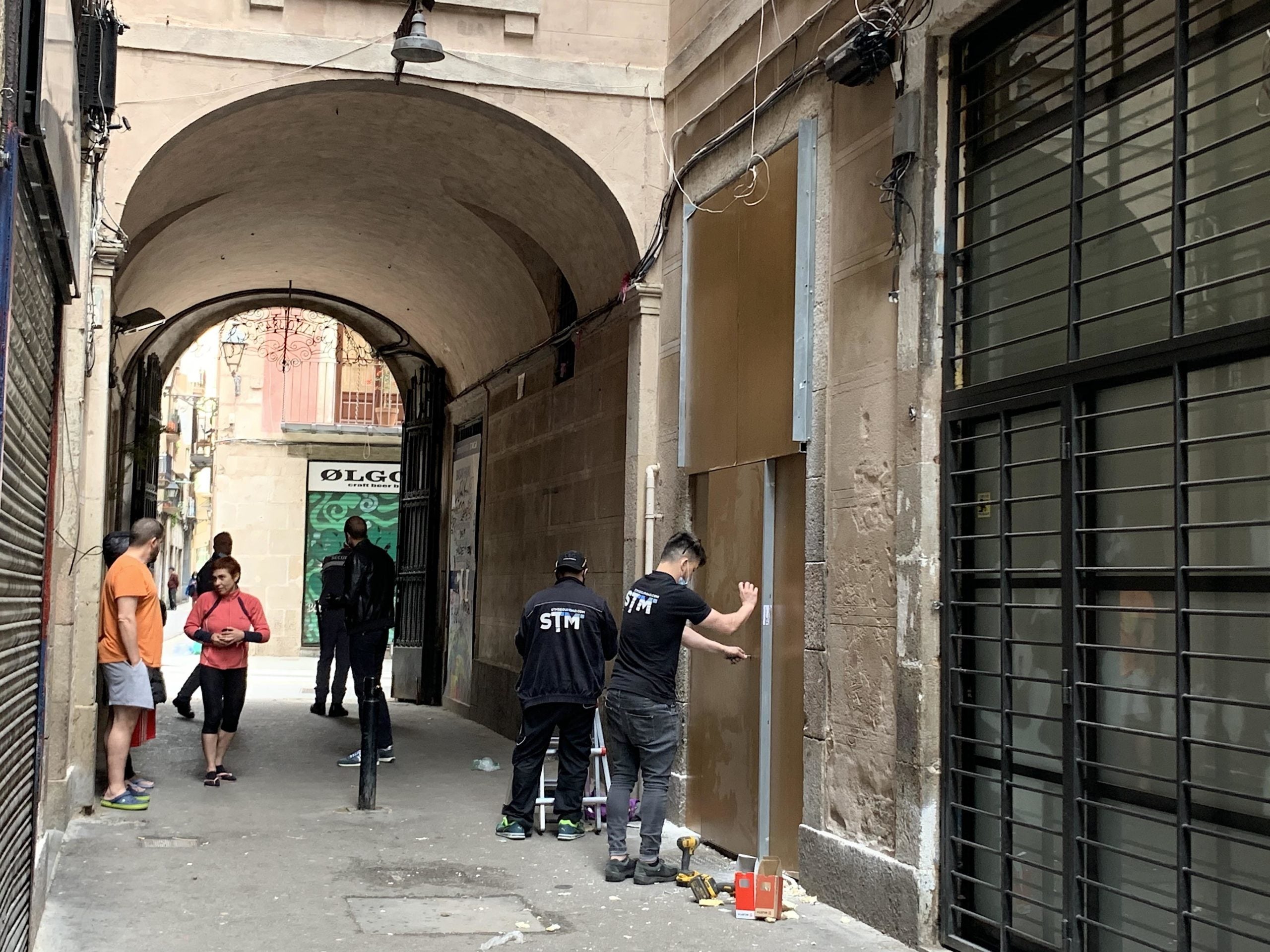 Operaris acabant de muntar la porta antiokupes després de desallotjar un grup de traficants del bloc del número 99 del carrer Hospital, guanyat al fons voltor Blackstone amb la lluita veïnal / S.B.