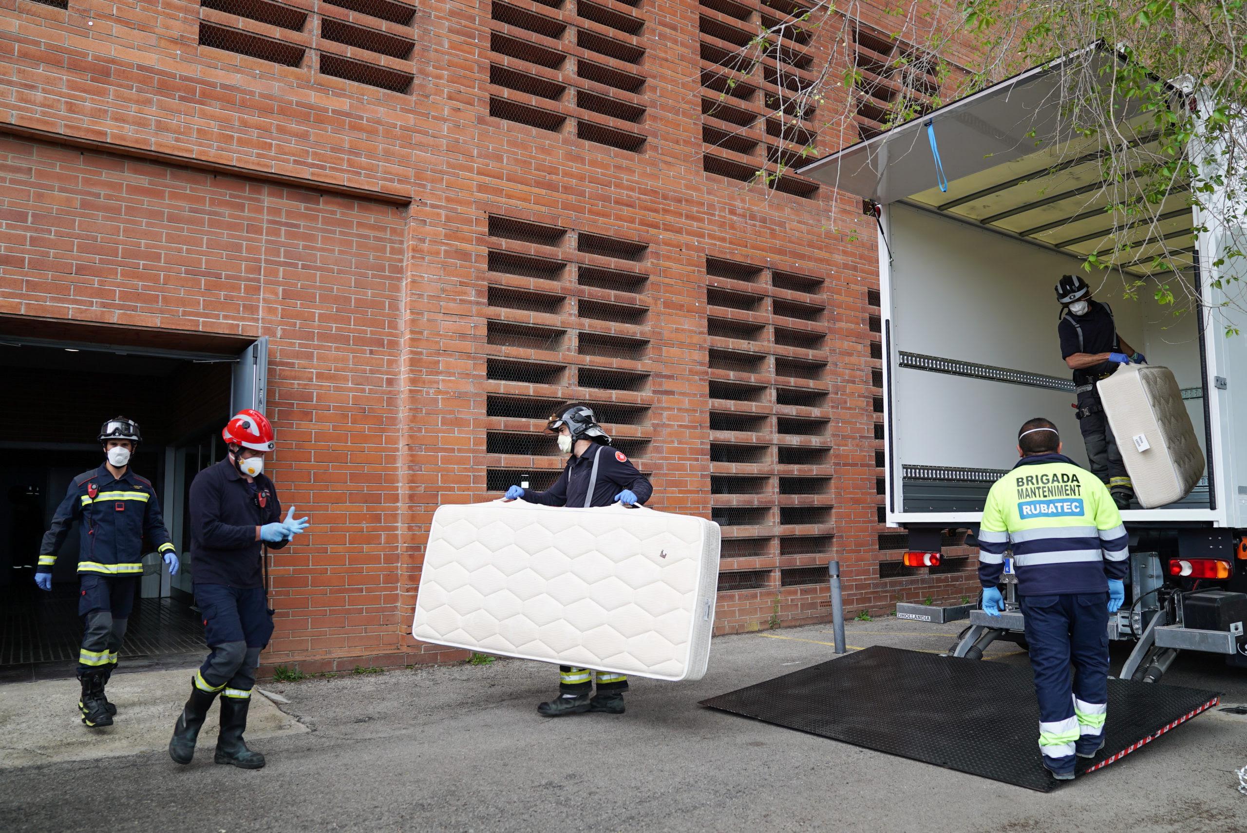 Bombers traslladen llits per habilitar un poliesportiu per rebre pacients de coronavirus / Ajuntament de Barcelona