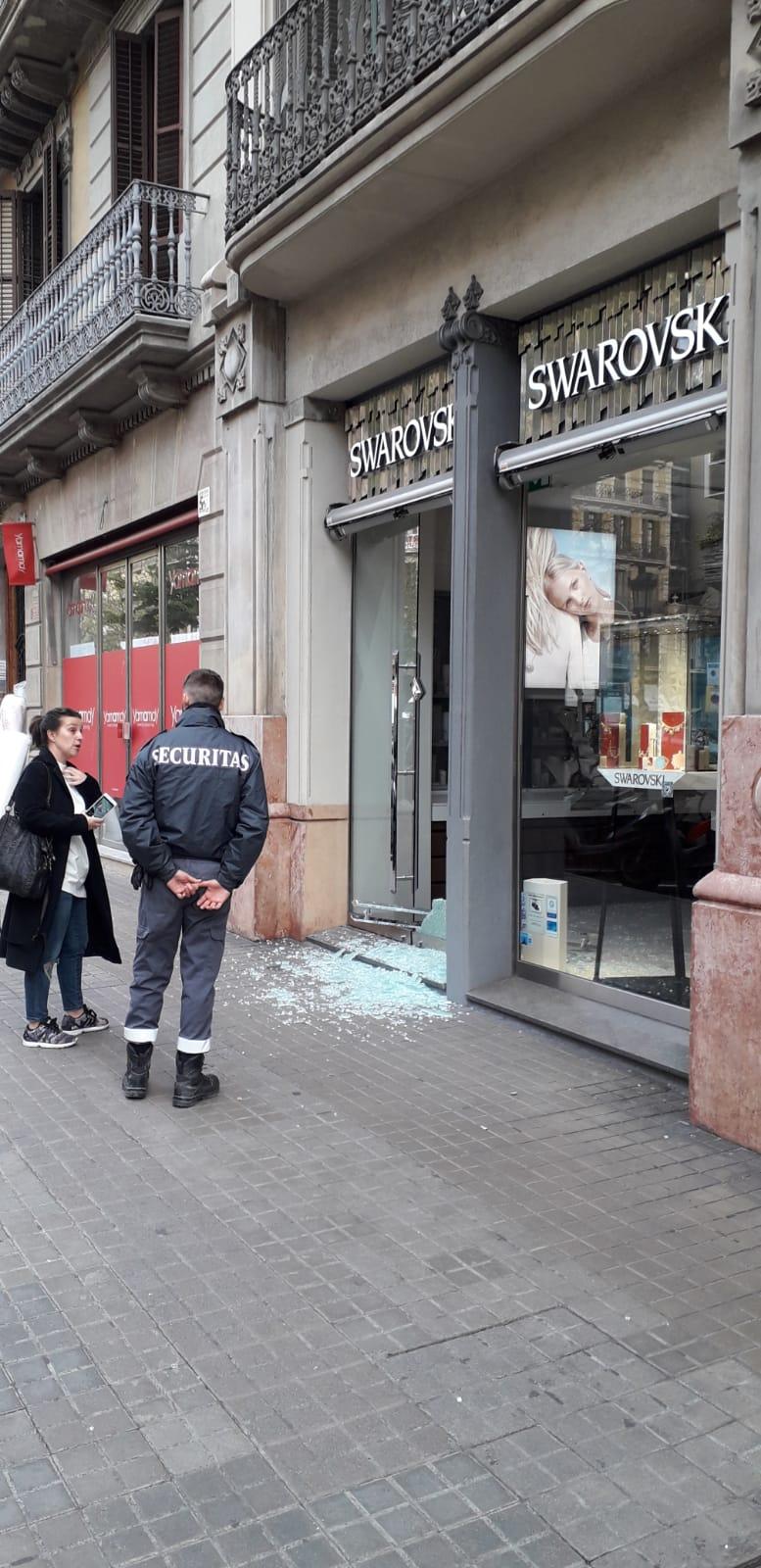 Un vigilant de seguretat custodia la porta de la botiga Swarovski on hi ha hagut el robatori | J.G.R.