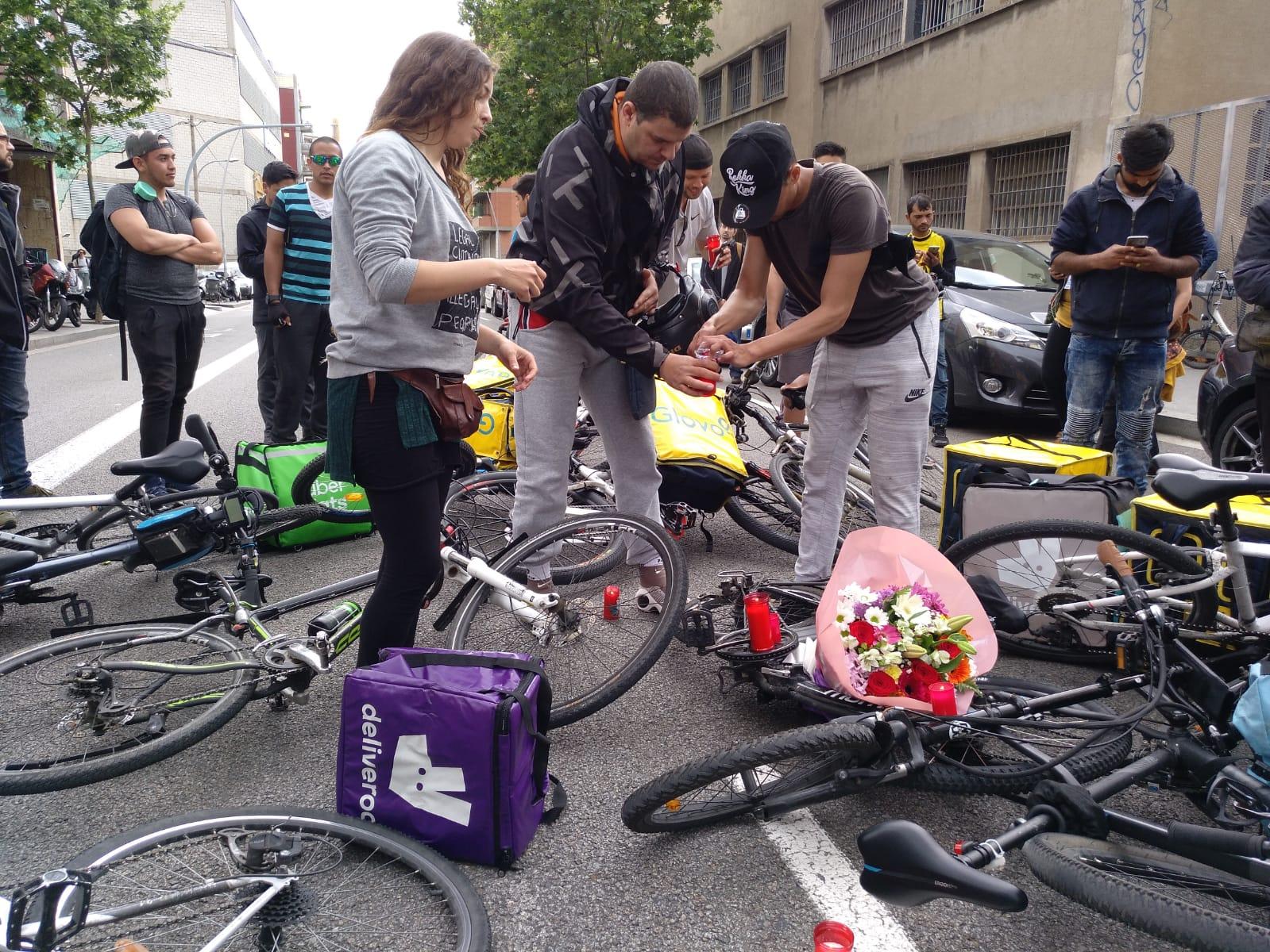 Tres concentrats encenen espelmes i posen flors sobre les bicicletes. / M. M. Pauné