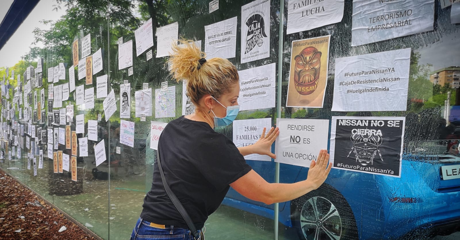 Una treballadora enganxa un cartell al concessionari de Nissan de Barcelona / D.C.