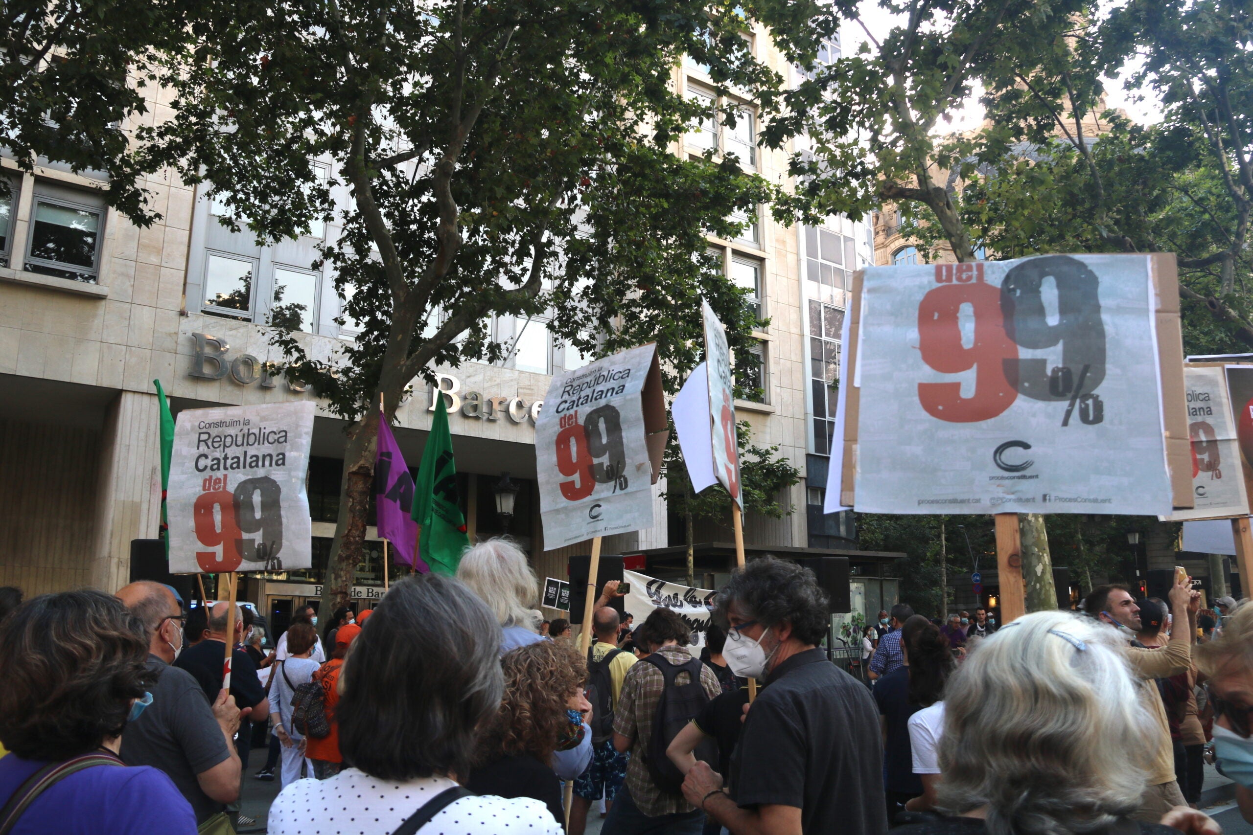 Cartells de protesta durant la manifestació organitzada per la plataforma Pla de Xoc Social davant la Borsa de Barcelona / ACN