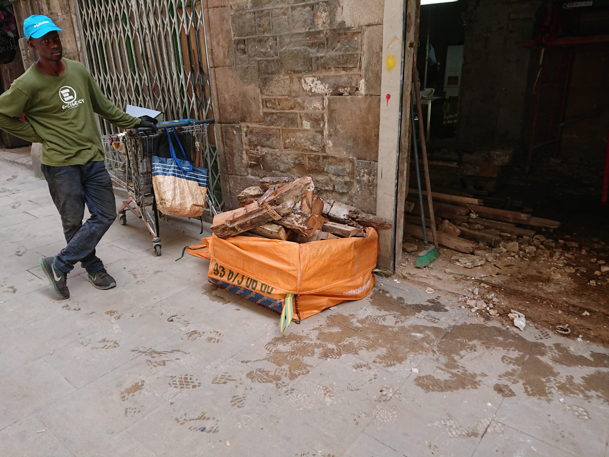 Un ferraller espera a la porta del palau Vilana-Perles a que els obrers li entreguin material de rebuig, aquest juliol / Cedida