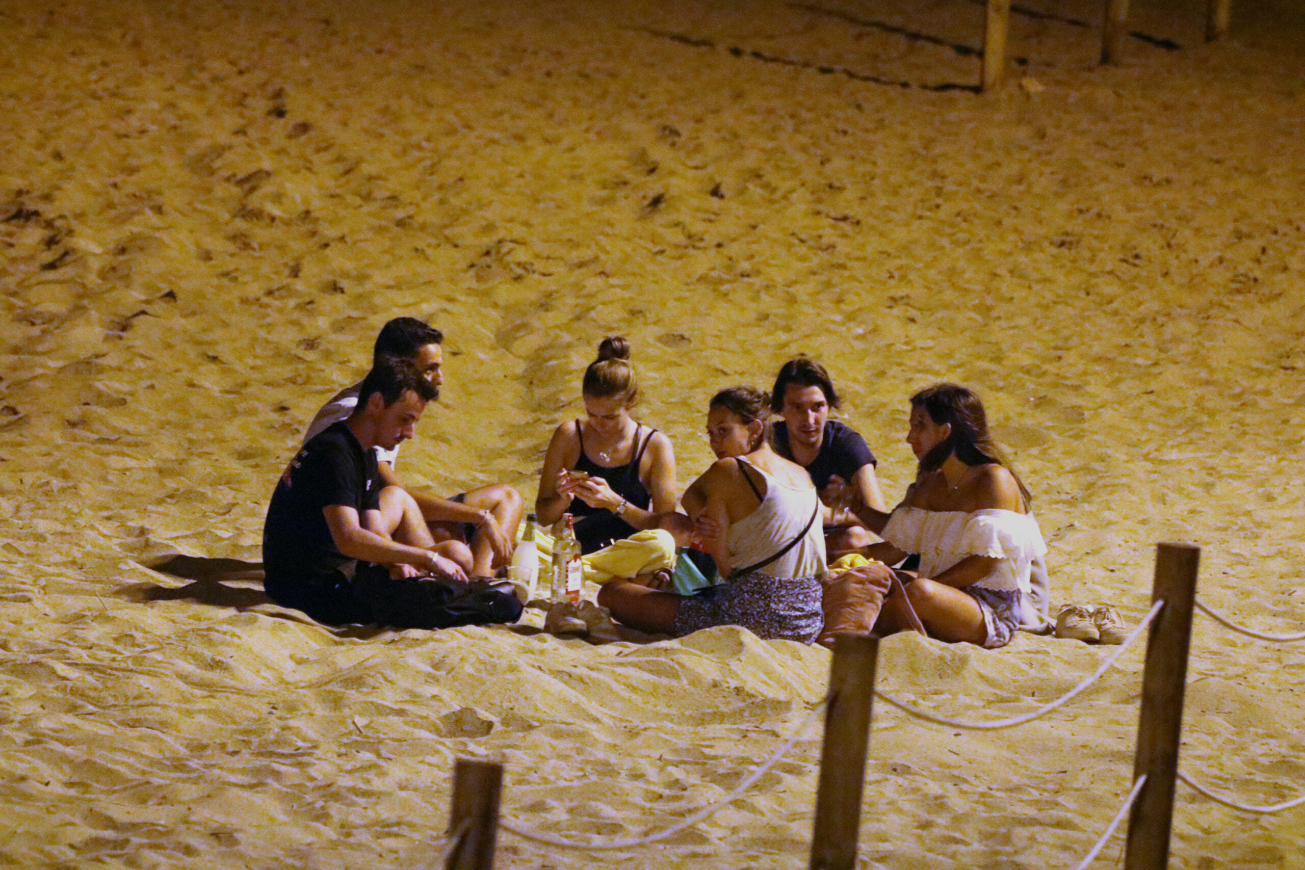 Un grup de persones fan el 'botellón' a la platja de la Barceloneta de Barcelona / ACN