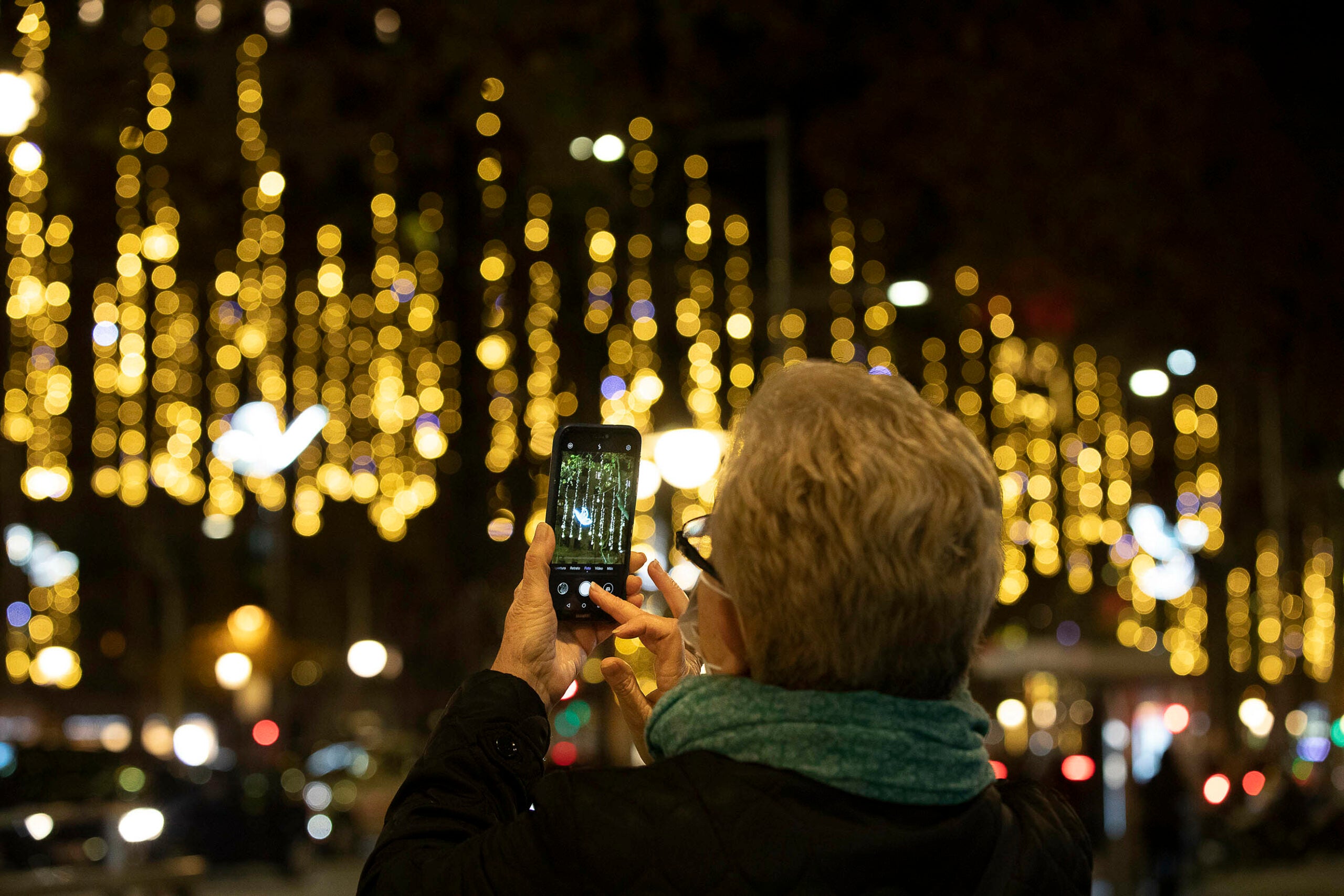 Una dona fotografia els llums de Nadal al Passeig de Gràcia / Jordi Play