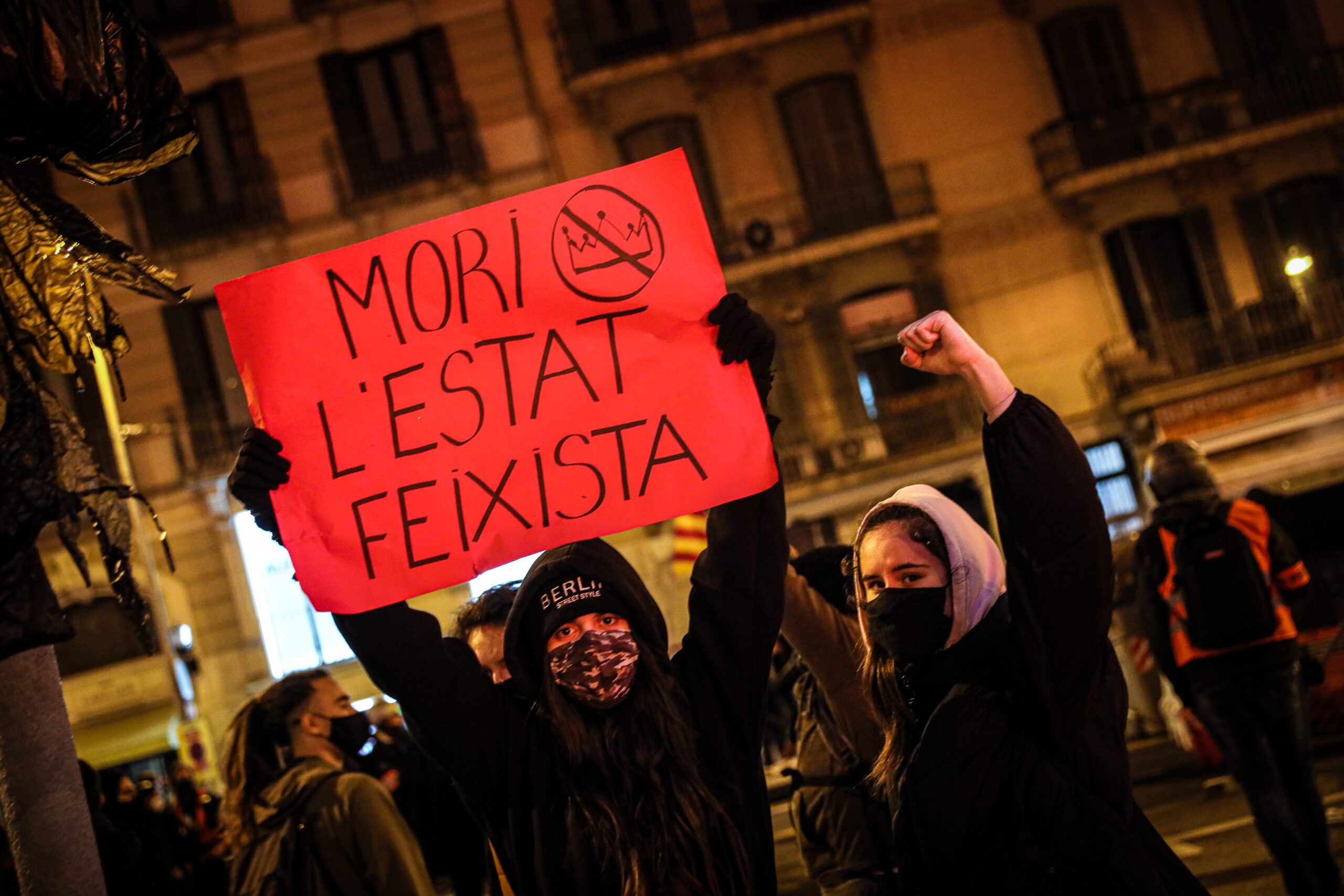 Uns manifestants amb un cartell de 'Mort a l'estat feixista', la segona nit d'aldarulls per Hasél / Jordi Borràs