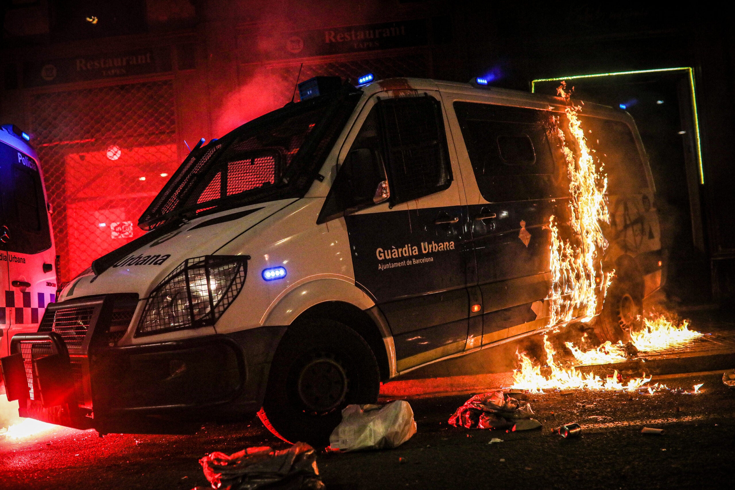 Una furgoneta de la Guàrdia Urbana, envoltada de foc després del llançament d'un còctel molotov / Jordi Borràs