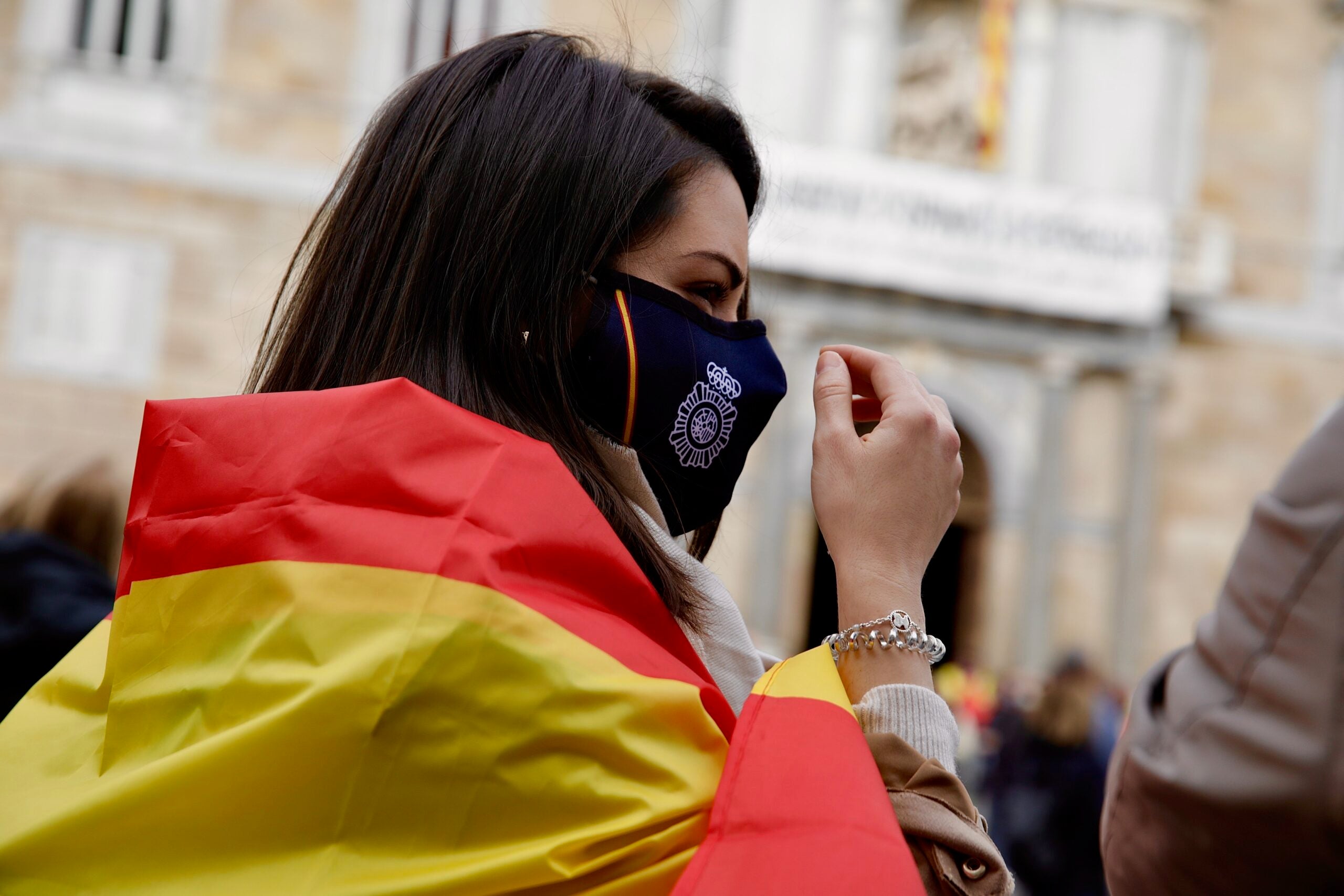 Una manifestant amb la bandera espanyola i una mascareta de la Policia Nacional / Jordi Play