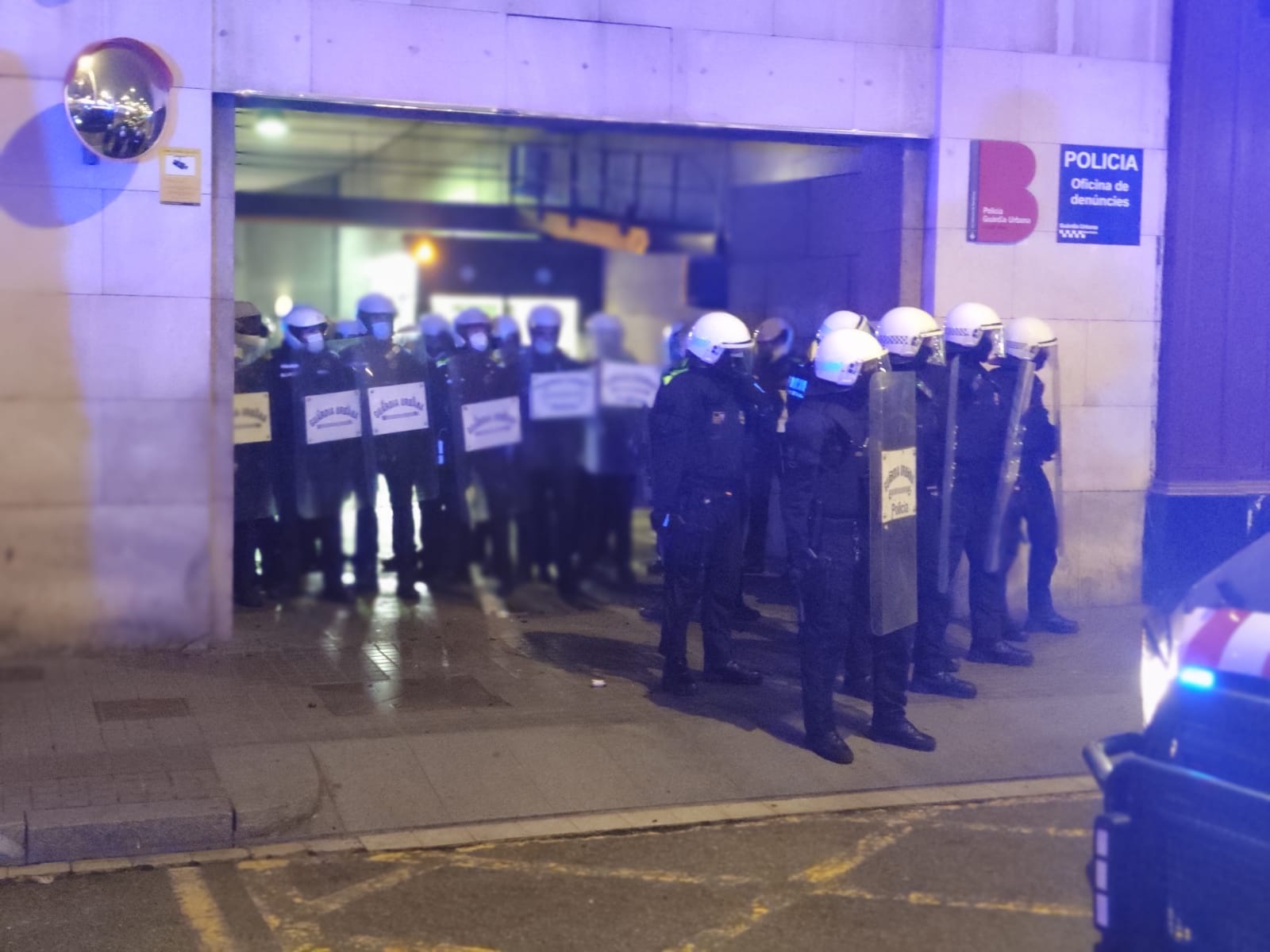 Agents de la Guàrdia Urbana defensant la comissaria de la Rambla, en la 4a nit de disturbis / D.C.