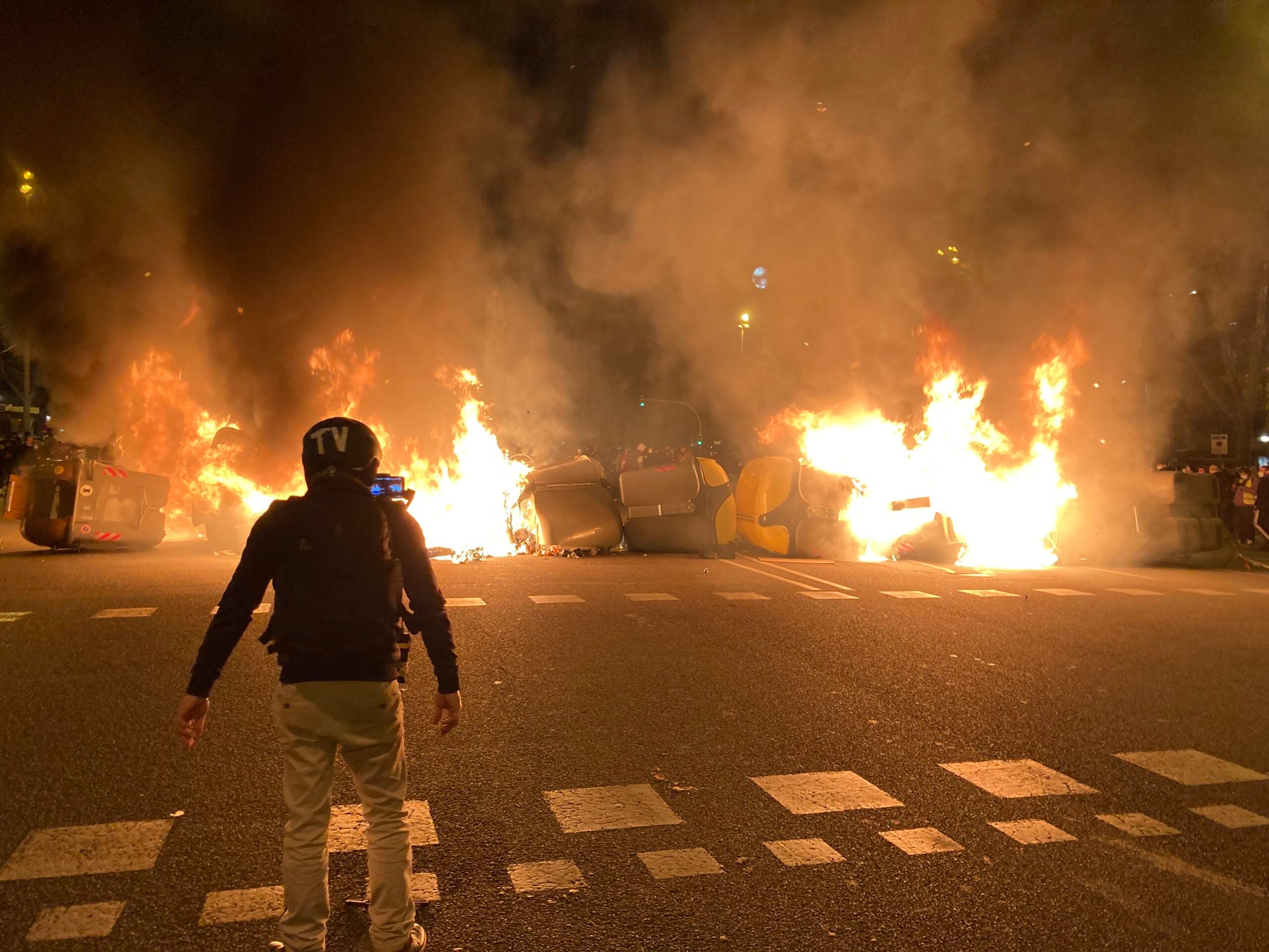 Un manifestant davant d'una barricada de contenidors encesa en la quarta nit de protestes per l'empresonament de Pablo Hasél / ACN