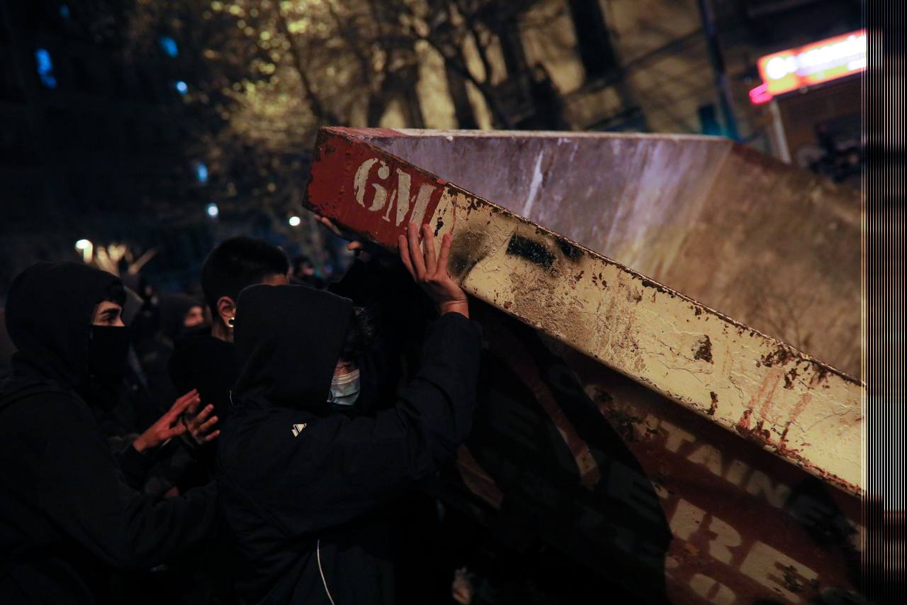 Joves aixecant un contenidor d'obra durant les protestes / Jordi Borràs