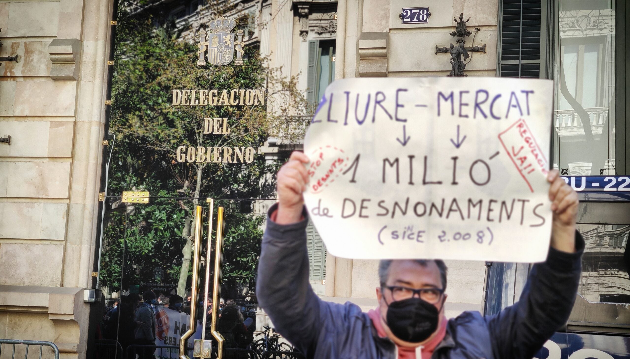 Un home sosté una pancarta per l'habitatge digne davant la delegació del govern espanyol / D.C.